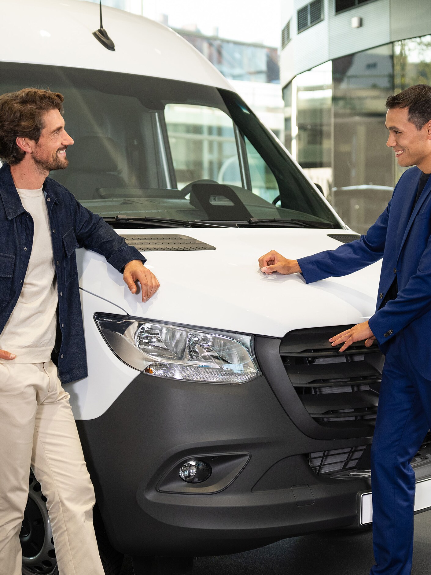 Dwie osoby opierające się o samochód dostawczy Mercedes-Benz i prowadzące rozmowę.