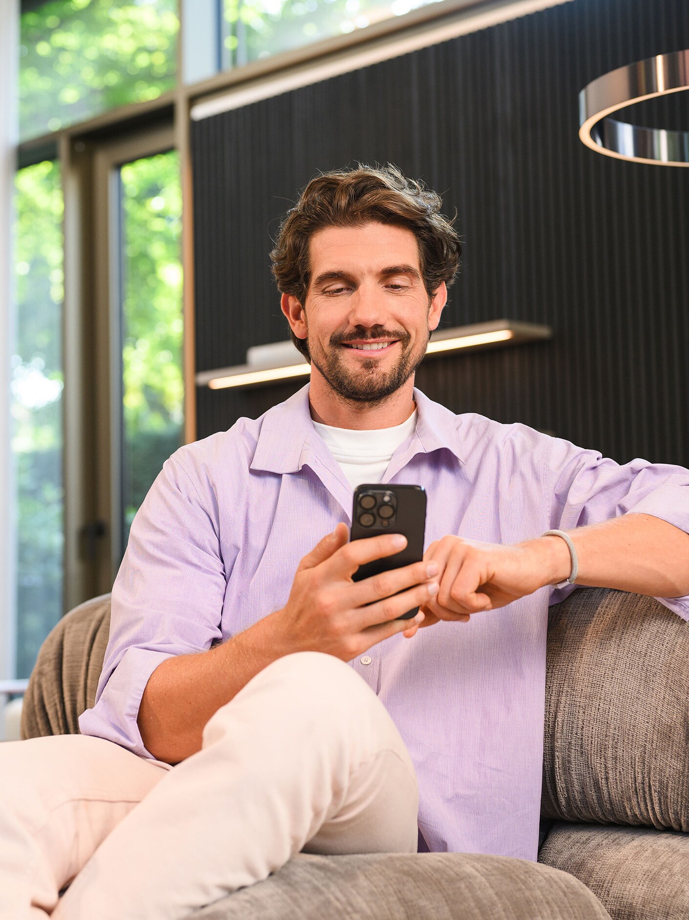 Osoba siedząca i korzystająca z urządzenia mobilnego.