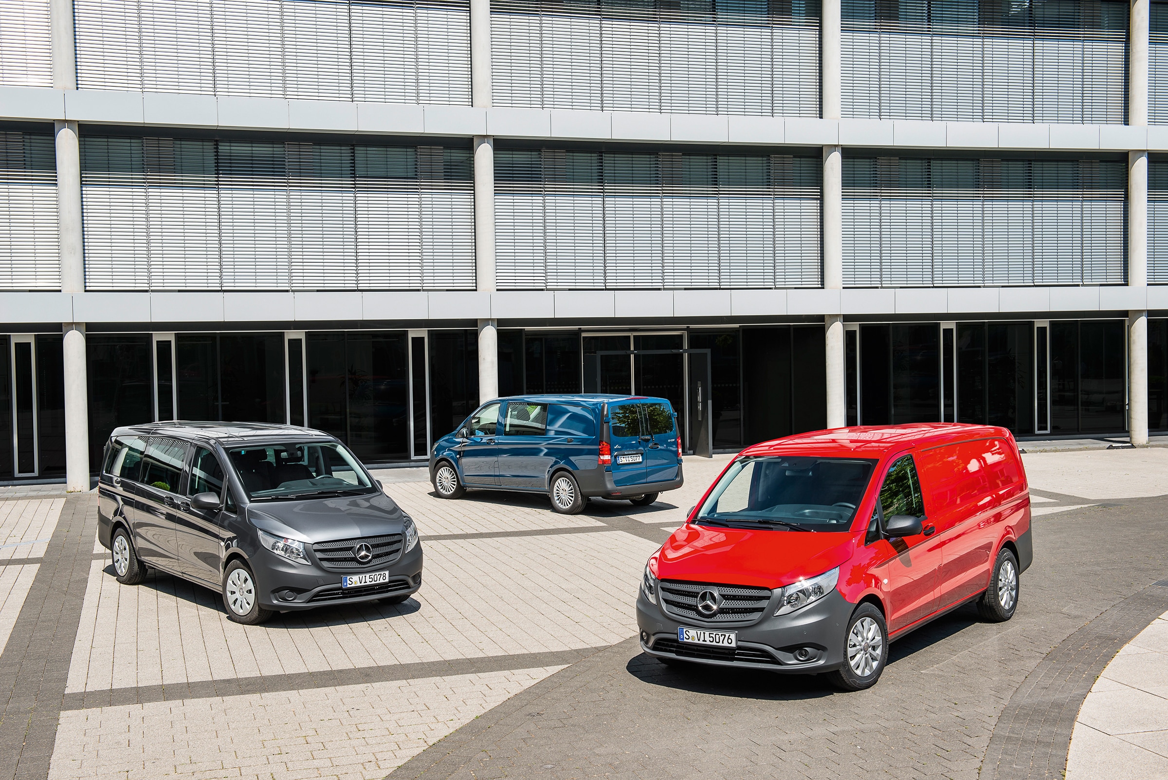 Trzecia generacja Mercedes-Benz Vito | Historia pojazdów użytkowych | Mercedes-Benz Kilka samochodów Mercedes-Benz Vito zaparkowanych przed nowoczesnym budynkiem biurowym