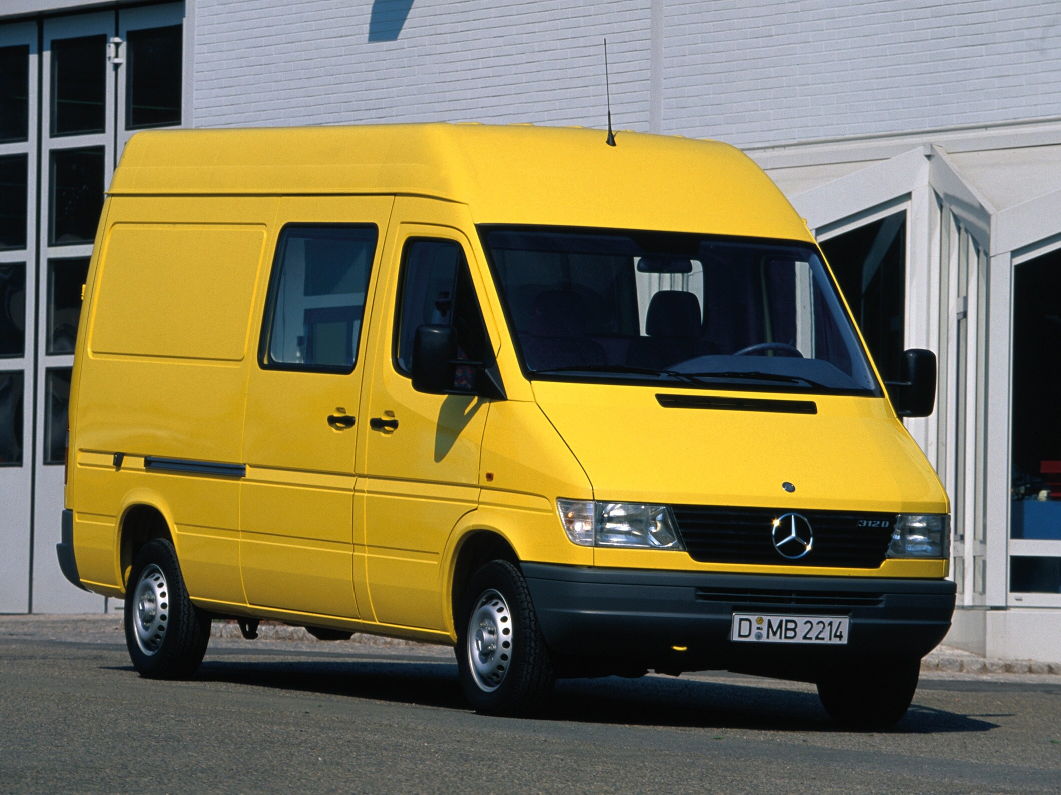 Mercedes-Benz Sprinter pierwszej generacji zaparkowany przed budynkiem przemysłowym