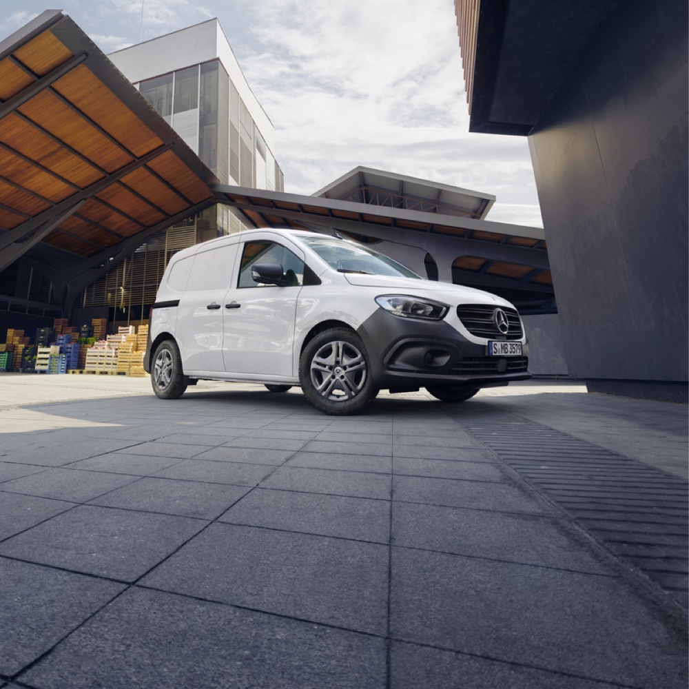 Ekonomiczna Obsługa Pogwarancyjna | Samochody dostawcze Mercedes-Benz Biały Mercedes-Benz Citan na tle industrialnego krajobrazu.
