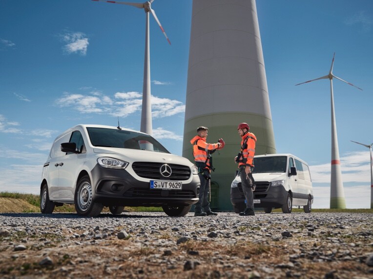 Dwa samochody dostawcze Mercedes-Benz na terenie budowy.