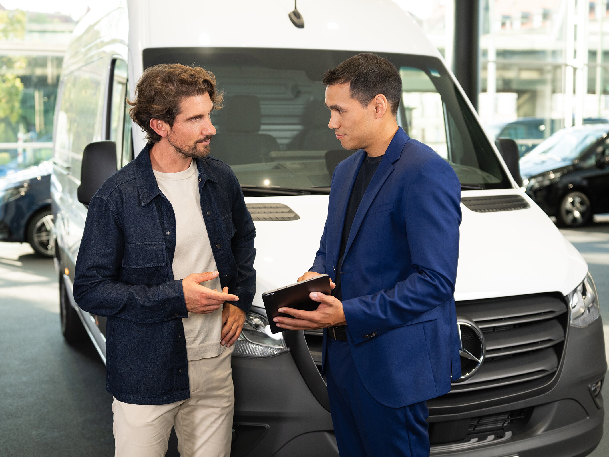 Konsultacje dotyczące samochodów dostawczych Mercedes-Benz w salonie, z naciskiem na obsługę zorientowaną na klienta.