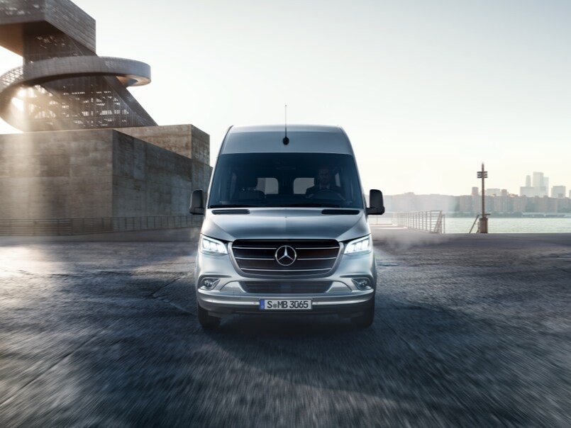 Srebrny Sprinter na tle budynków przemysłowych.