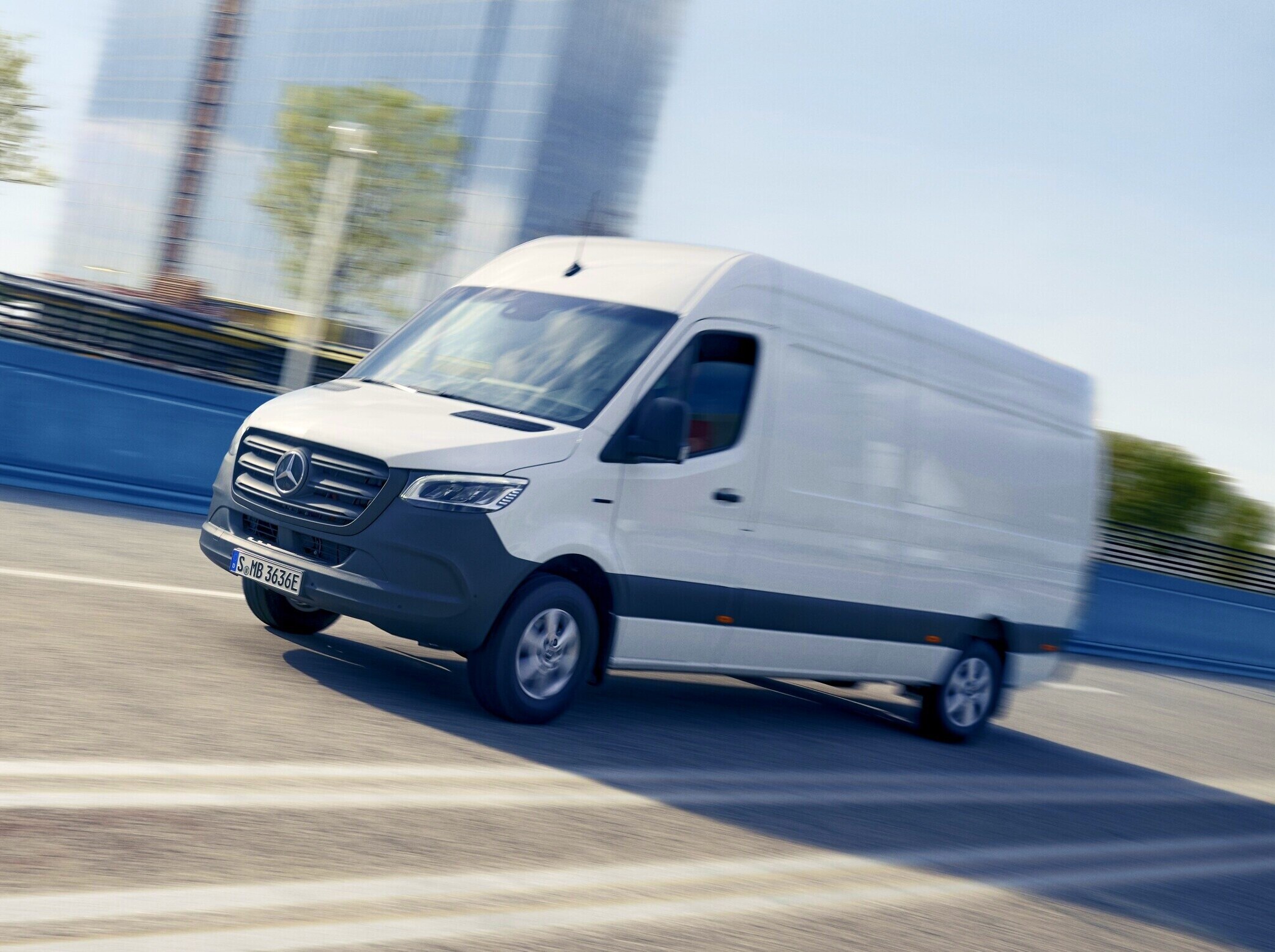 Biały Mercedes-Benz Sprinter na wielopasmowej drodze.
