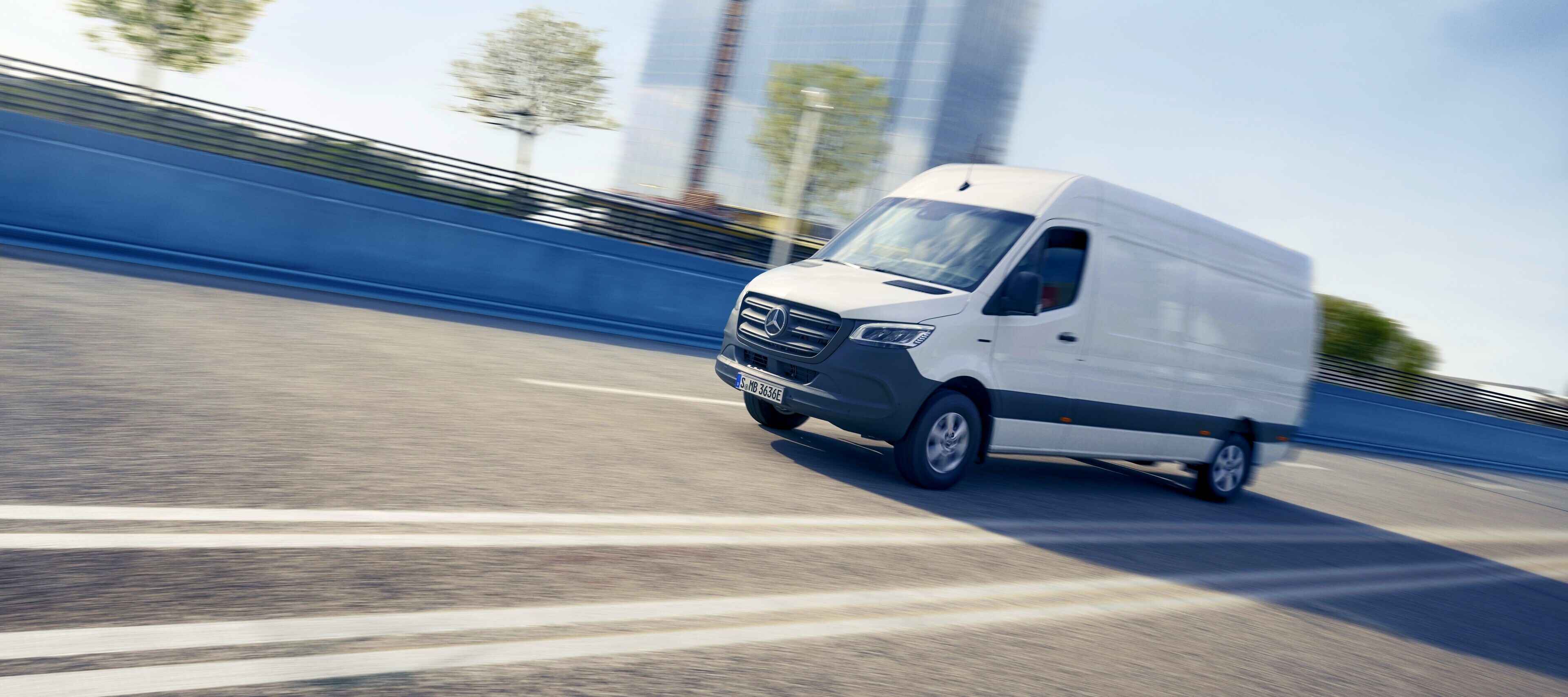 Ekonomiczna Obsługa Pogwarancyjna | Samochody dostawcze Mercedes-Benz Biały Mercedes-Benz Sprinter na wielopasmowej drodze.