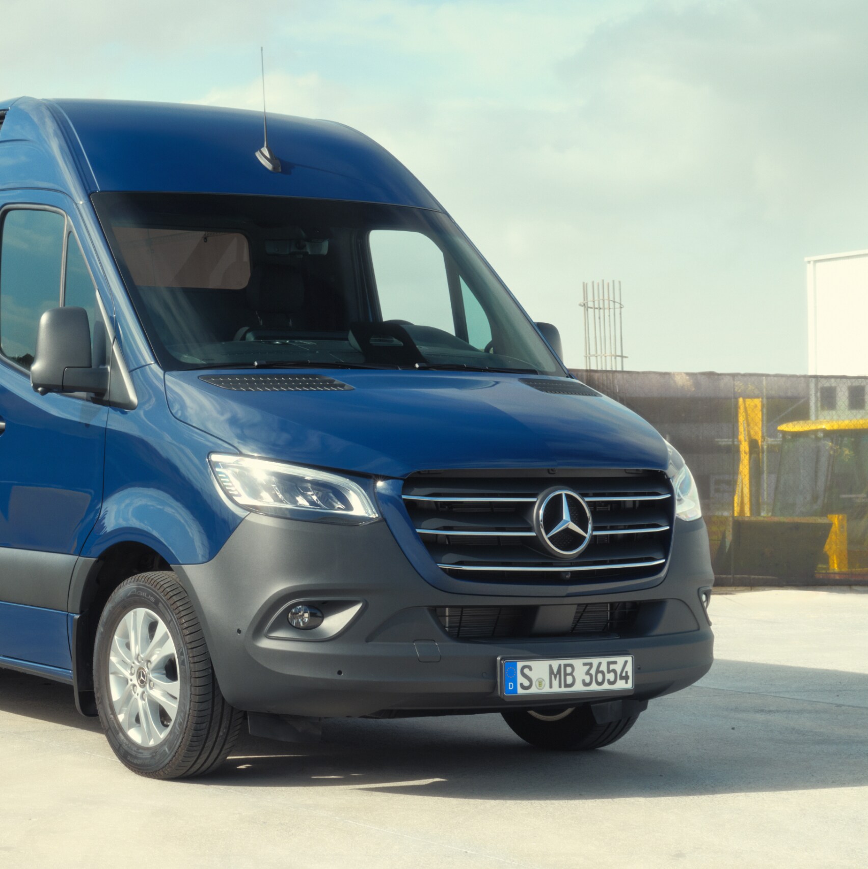 Mercedes-Benz Sprinter Furgon stojący przed materiałami budowlanymi.