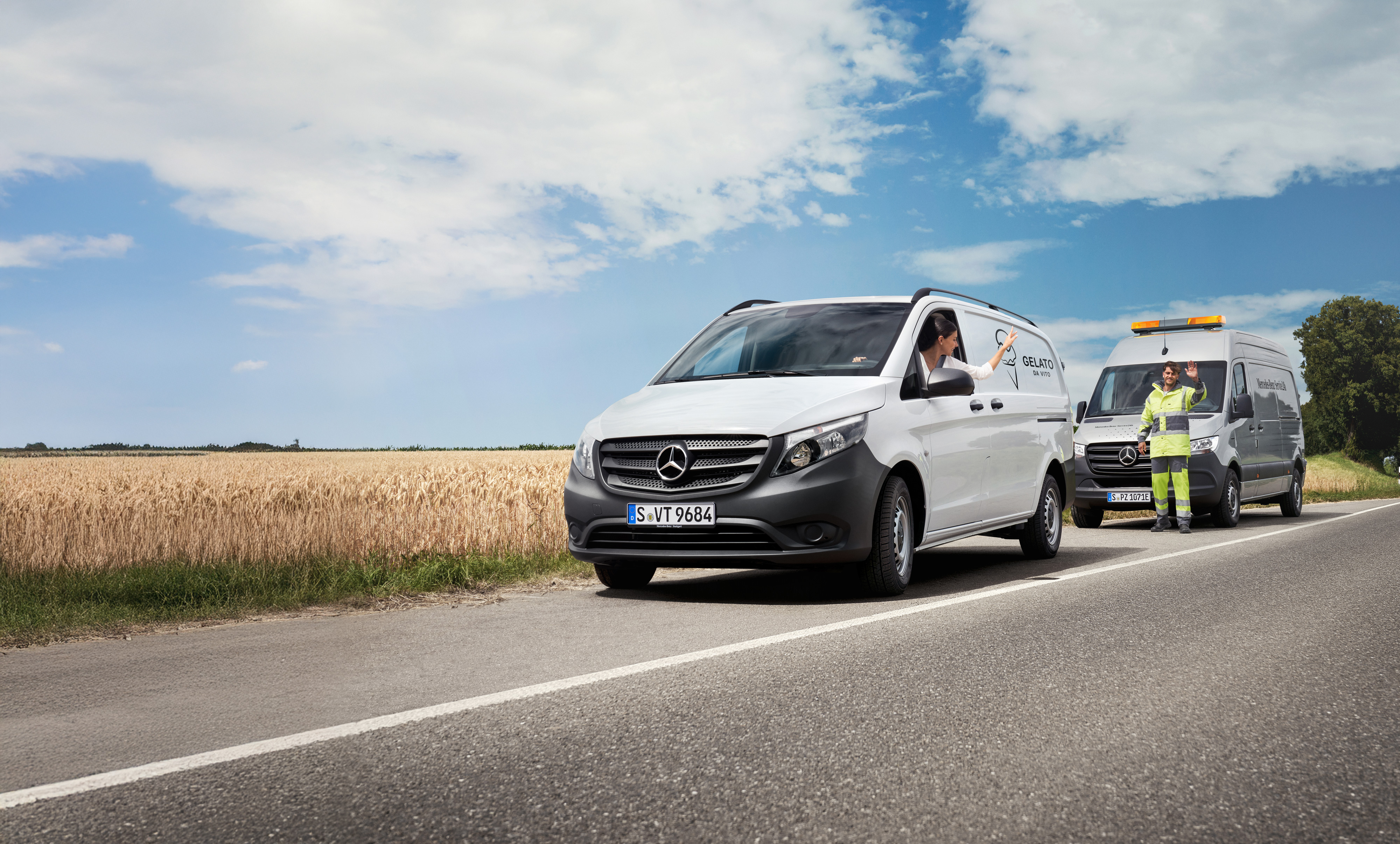 MobiloVan | Samochody dostawcze Mercedes-Benz Kobieta siedząca w białym samochodzie Mercedes-Benz Vito macha do doradcy serwisowego Mercedes-Benz na poboczu drogi.