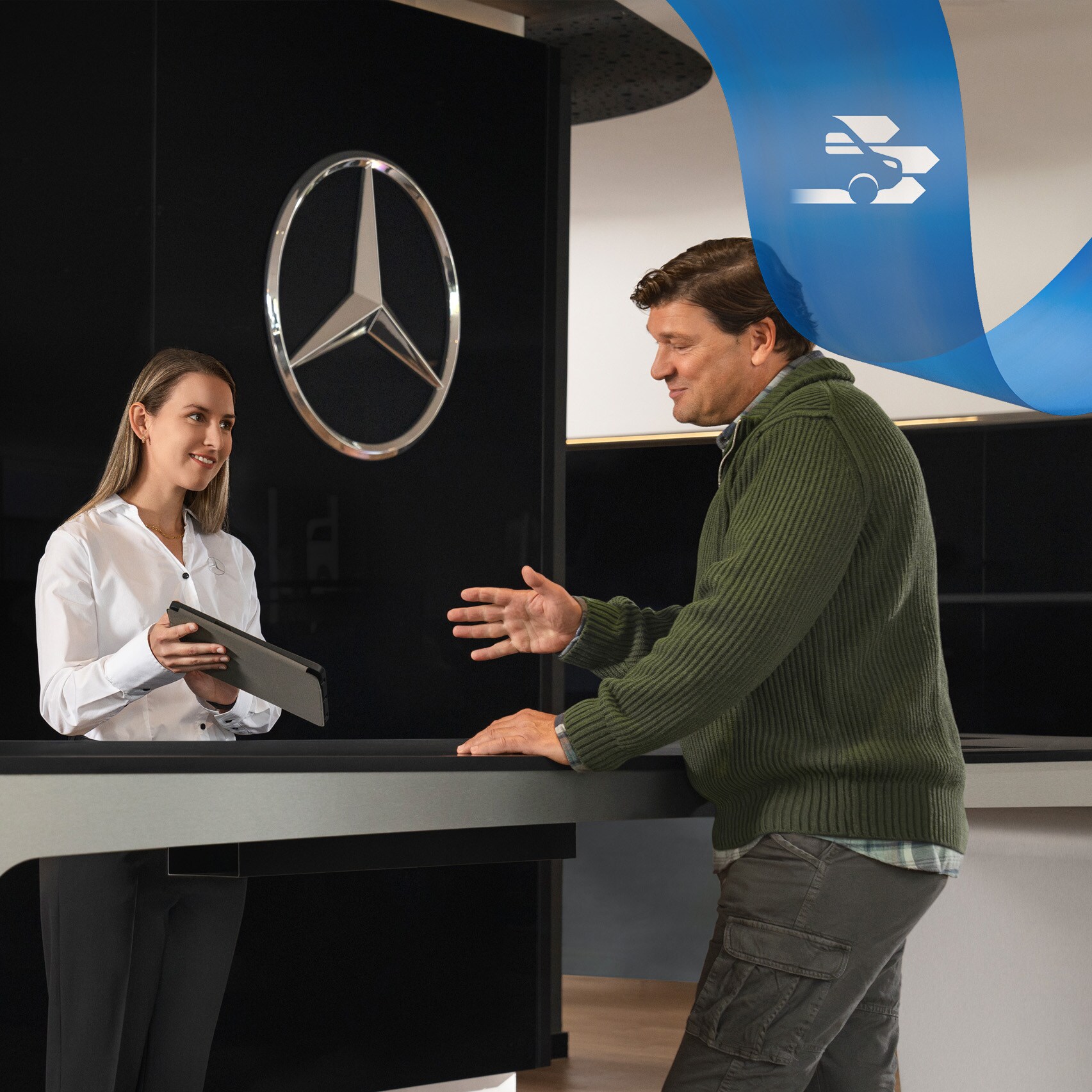 Pracownik Mercedes-Benz udziela wsparcia klientowi stojąc w recepcji.