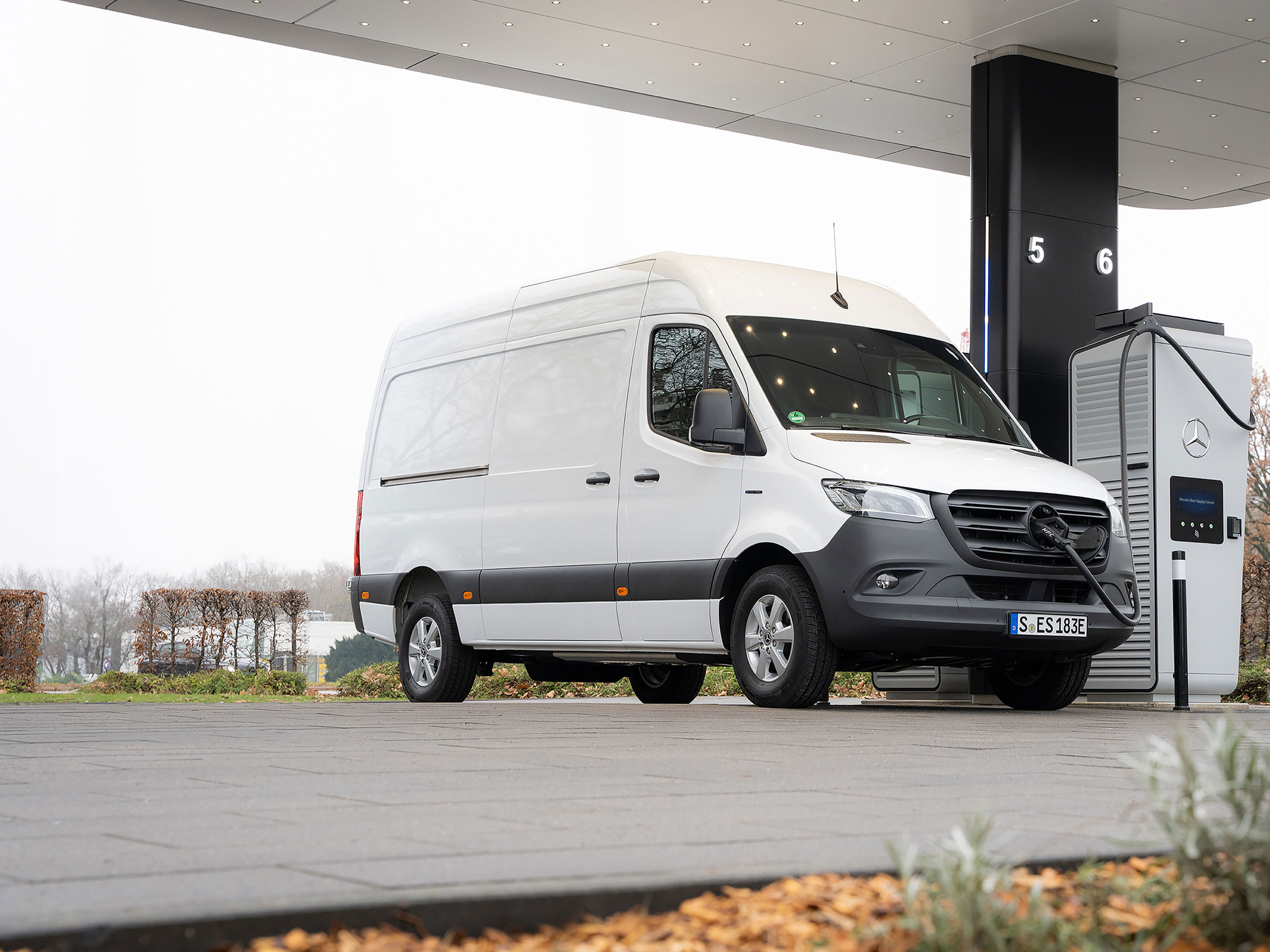 Sieć ładowania Mercedes-Benz | Ładowanie w drodze | Samochody dostawcze Mercedes-Benz Samochód dostawczy Mercedes-Benz przed stacją ładowania podczas ładowania.