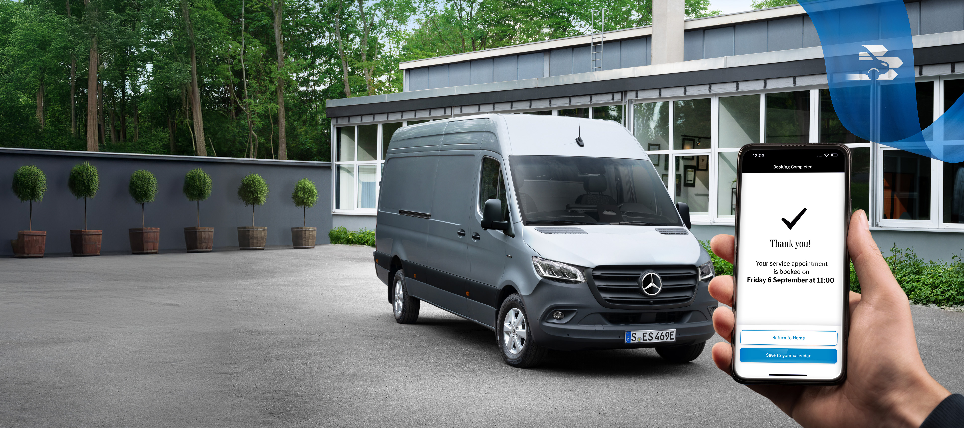 Rezerwacja terminu online | Samochody dostawcze Mercedes-Benz Szary samochód Mercedes-Benz Sprinter stojący przed biurem z osobą trzymającą smartfon na pierwszym planie.