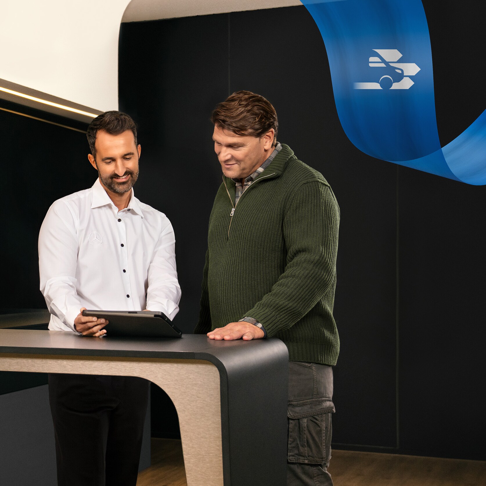 Dwóch mężczyzn stojących w siedzibie partnera serwisowego Mercedes-Benz.