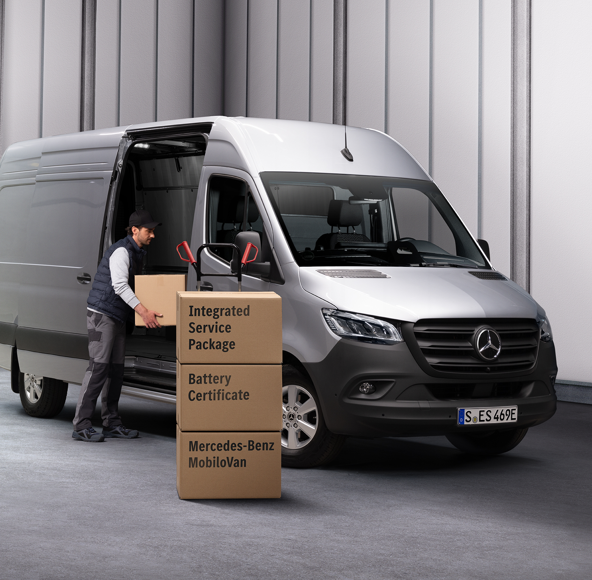 Partner serwisowy Mercedes-Benz | Zintegrowany pakiet przeglądów Osoba wyładowuje kartony z pojazdu Mercedes-Benz eSprinter. Trzy kartony ułożone w stos przed samochodem dostawczym. Na kartonach umieszczone są etykiety z nazwami produktów Umów serwisowych Mercedes-Benz.