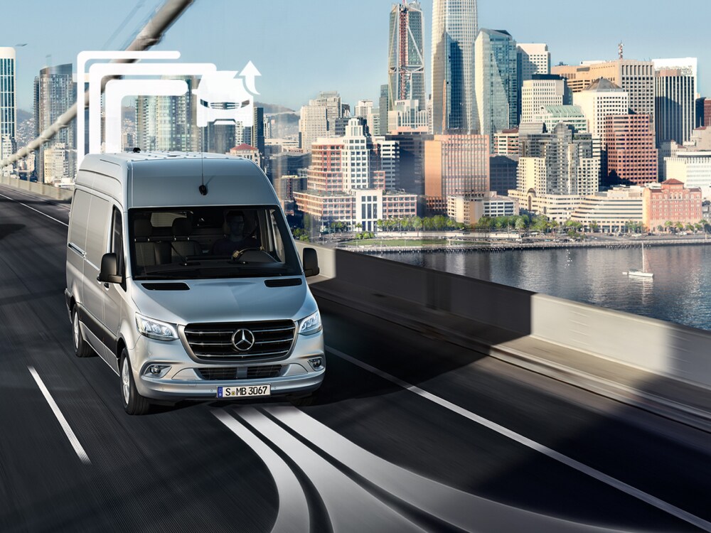 Samochód dostawczy Mercedes-Benz Vans przejeżdża przez wielopasmowy most w ciągu dnia.