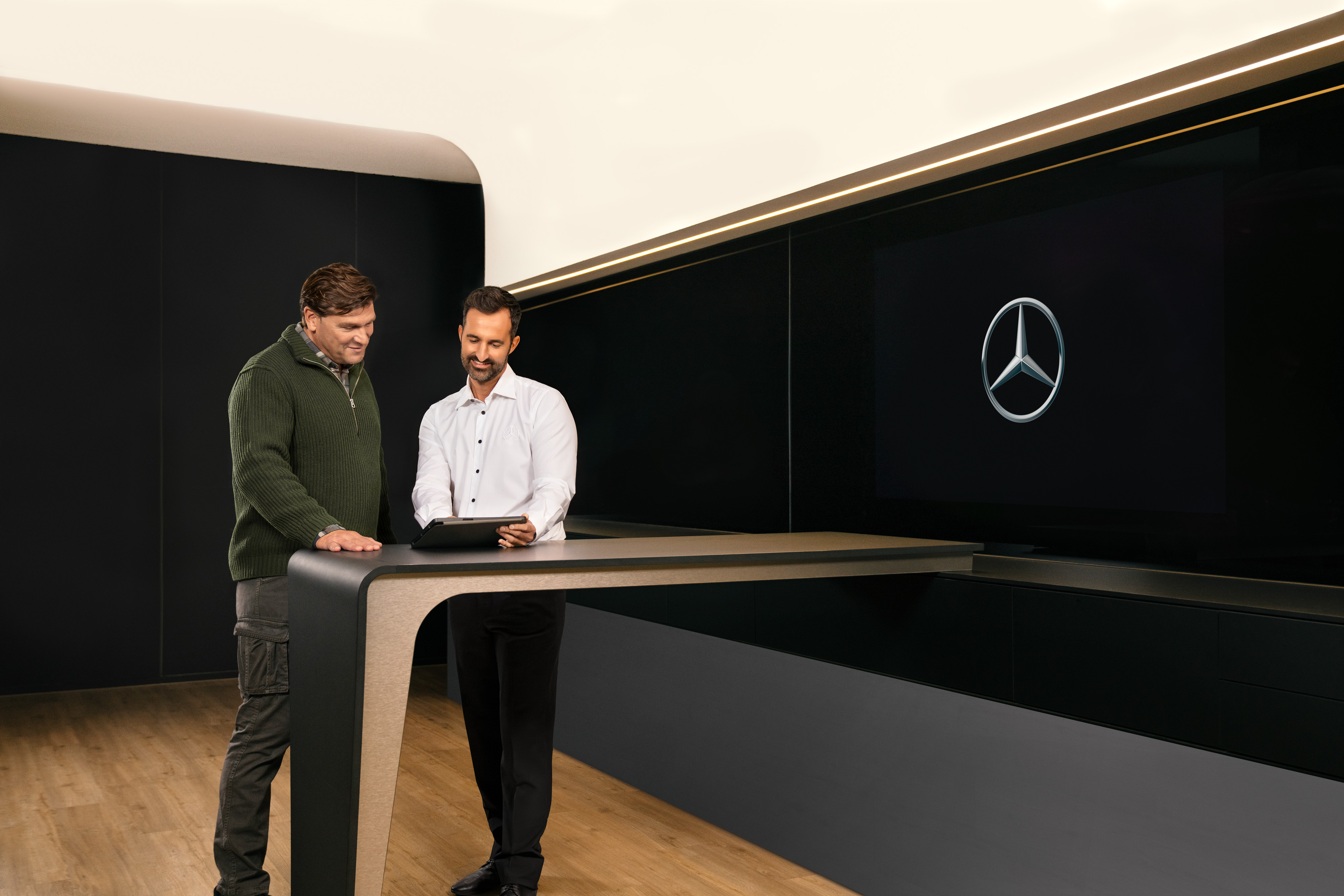 Mercedes-Benz | Przegląd usług | Umowy Serwisowe Mercedes-Benz Dwóch mężczyzn omawia usługi Mercedes-Benz dla pojazdów użytkowych nad tabletem.
