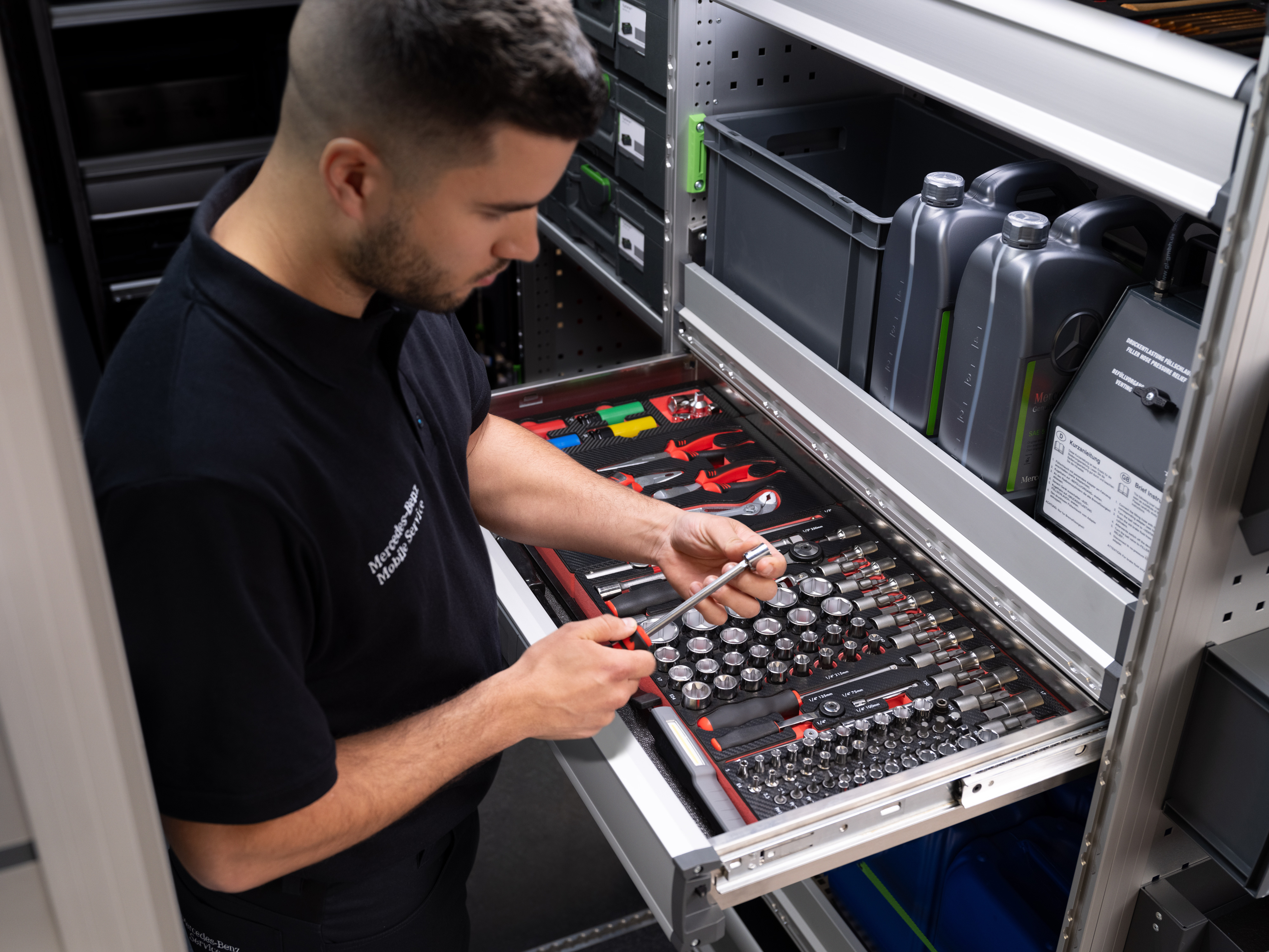 Mercedes-Benz | Serwis mobilny | Elektronika Technik wybiera przedmiot z szuflady pełnej narzędzi.