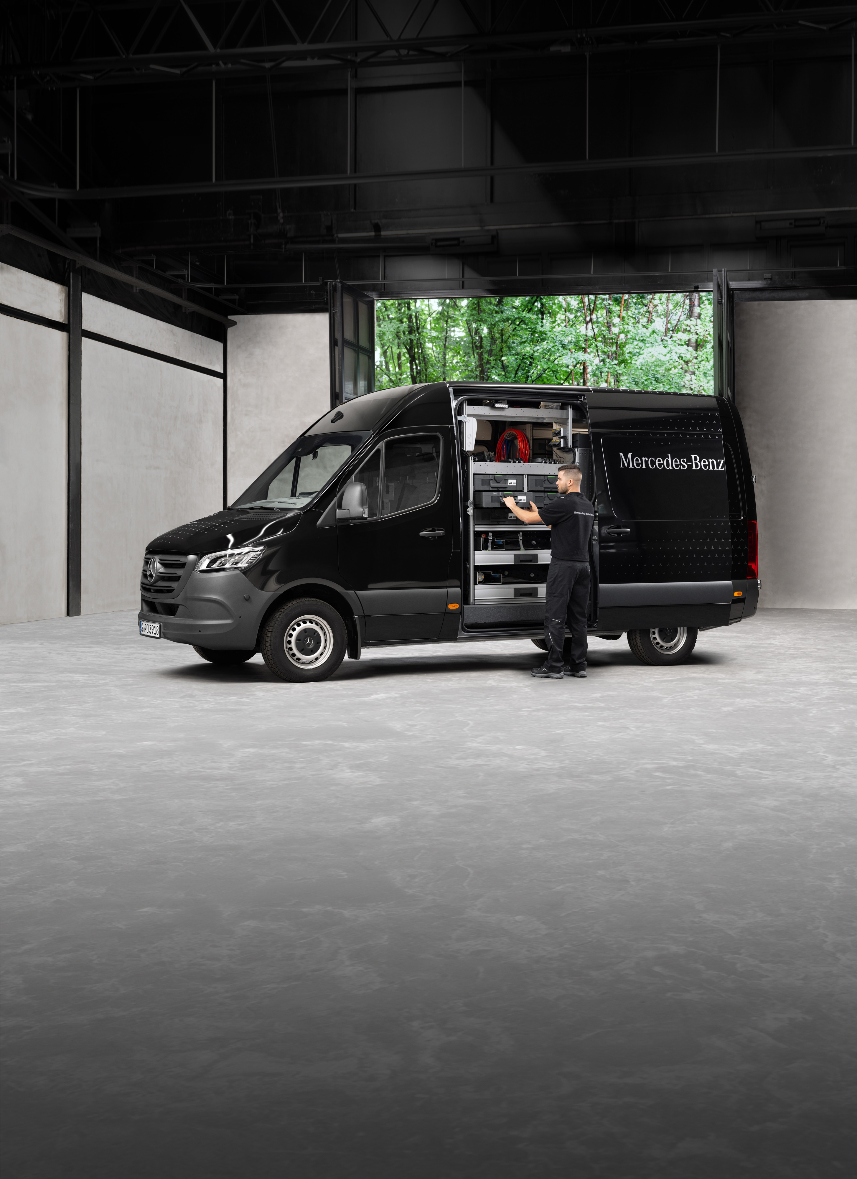 Mercedes-Benz | Serwis mobilny | Kontrola sezonowa Technik wyjmuje narzędzia z czarnego samochodu dostawczego Mercedes-Benz Sprinter.