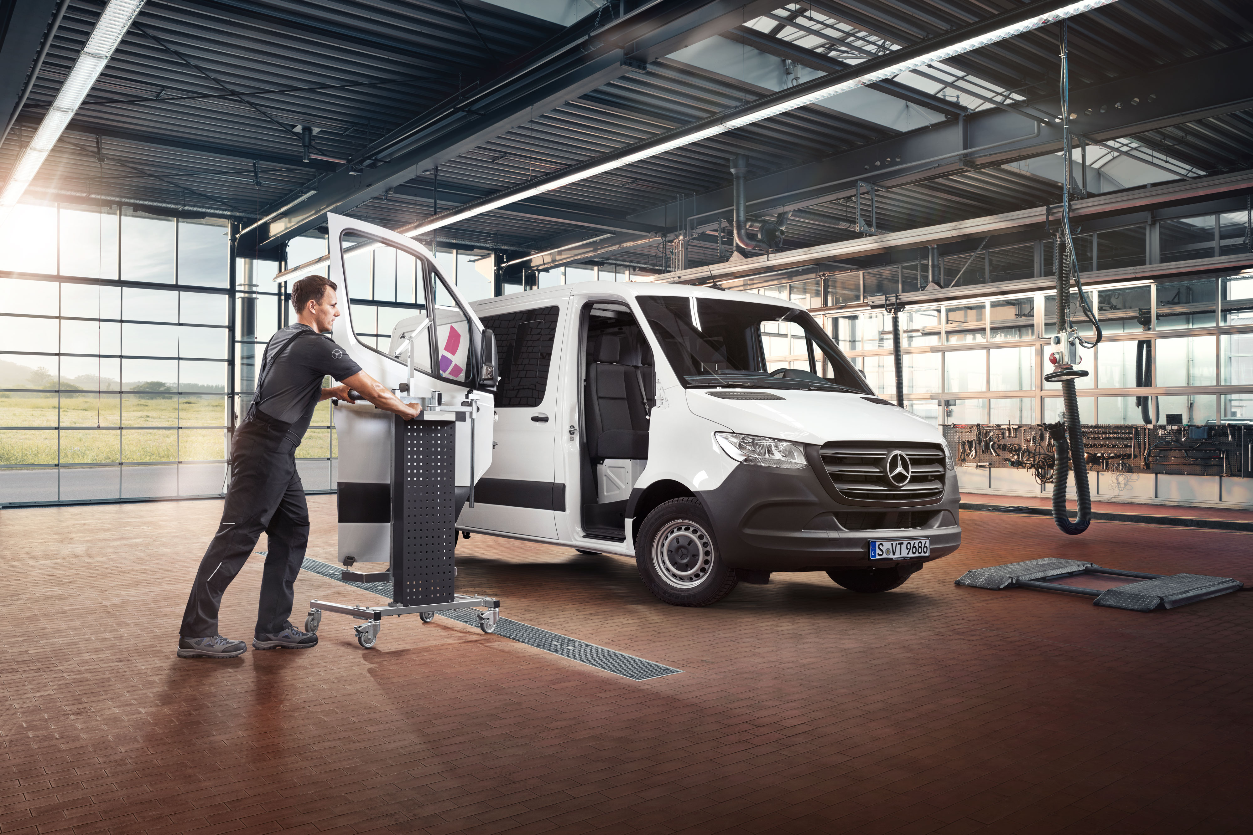 Mercedes-Benz | Naprawy Mechanik montuje drzwi w białym samochodzie Mercedes-Benz Sprinter.