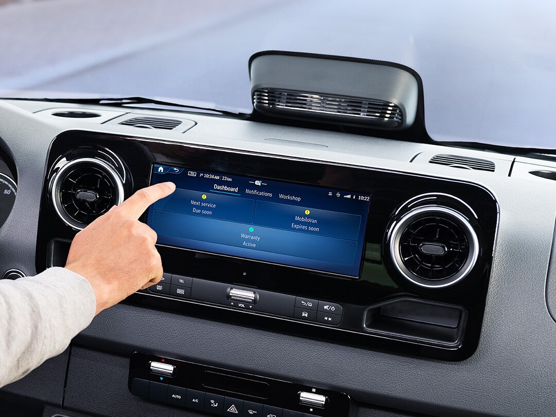 Kierowca korzystający z aplikacji Service na pokładowym wyświetlaczu, aby sprawdzić dane pojazdu i opcje serwisu.