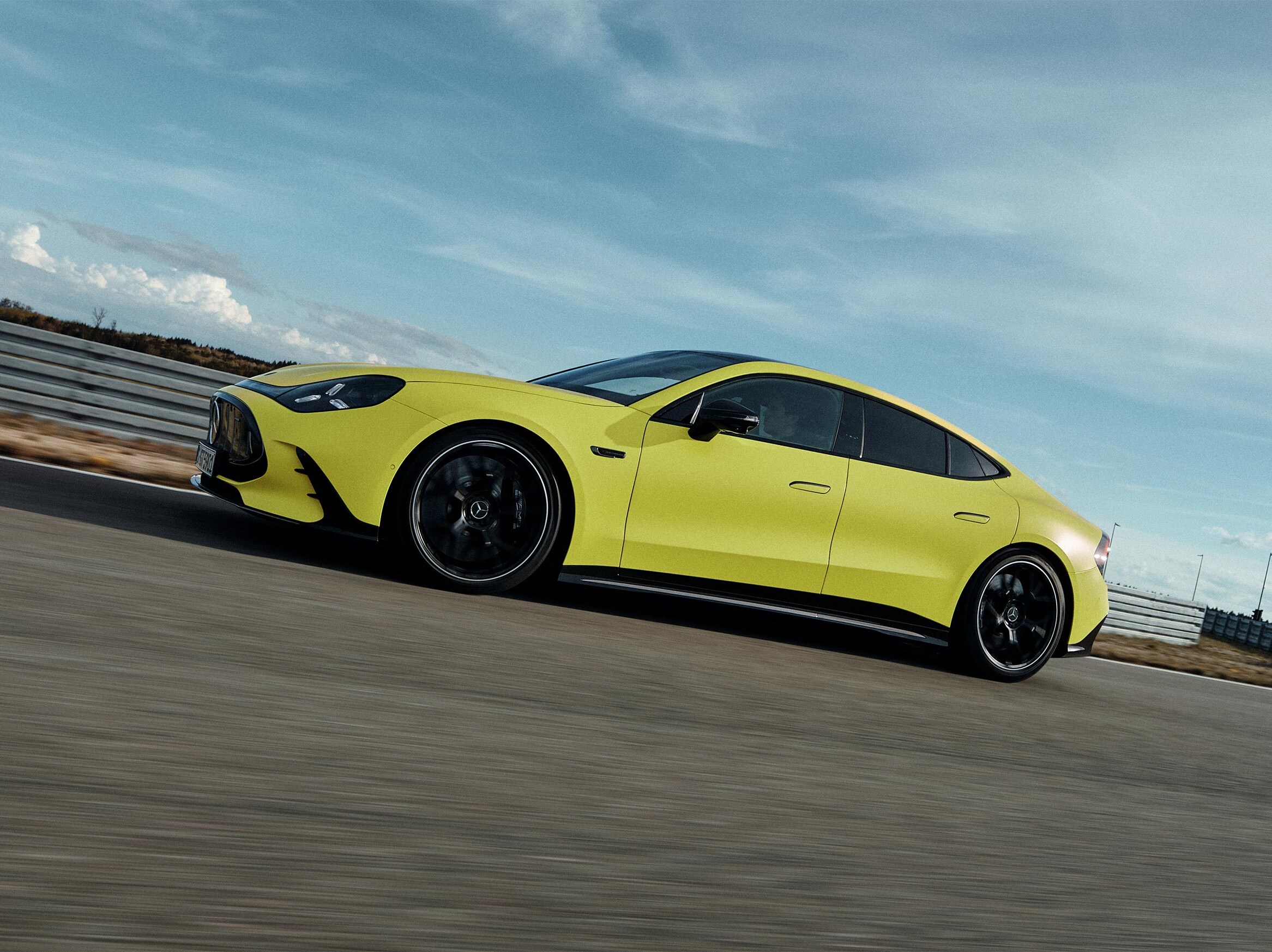 Żółty Mercedes-AMG GT 63 4-Door  Coupé na torze wyścigowym.