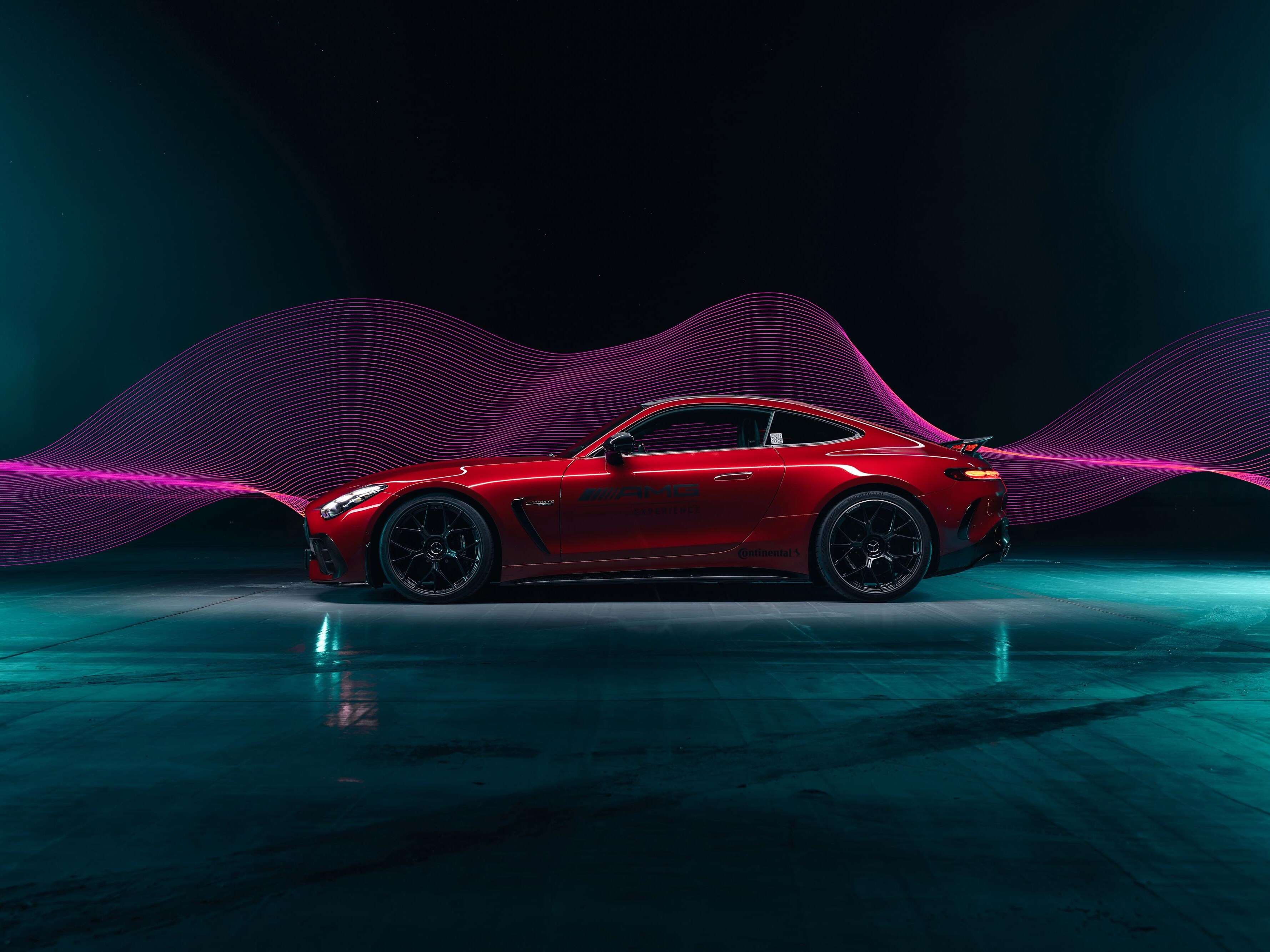 Czerwony Mercedes-AMG GT Coupé z logo AMG Experience na drzwiach.