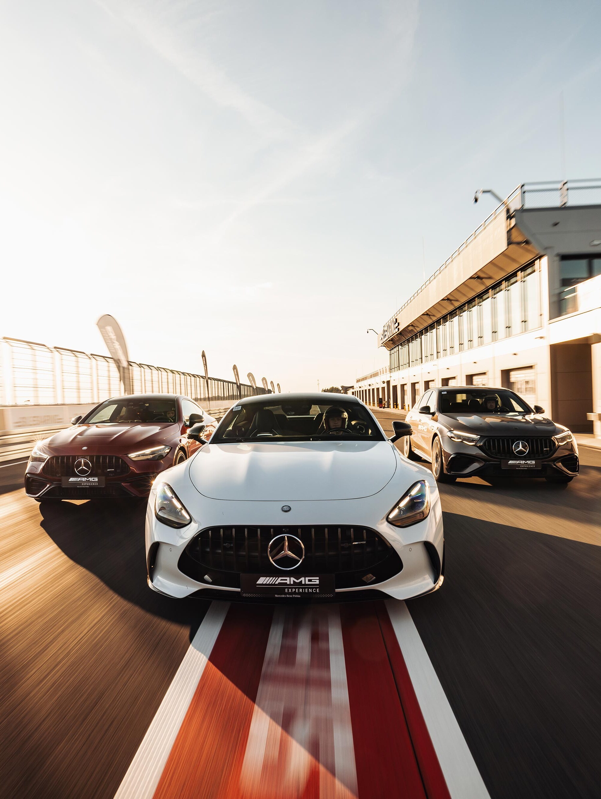 Samochody Mercedes-AMG jadące przez Pit Stop na torze wyścigowym.