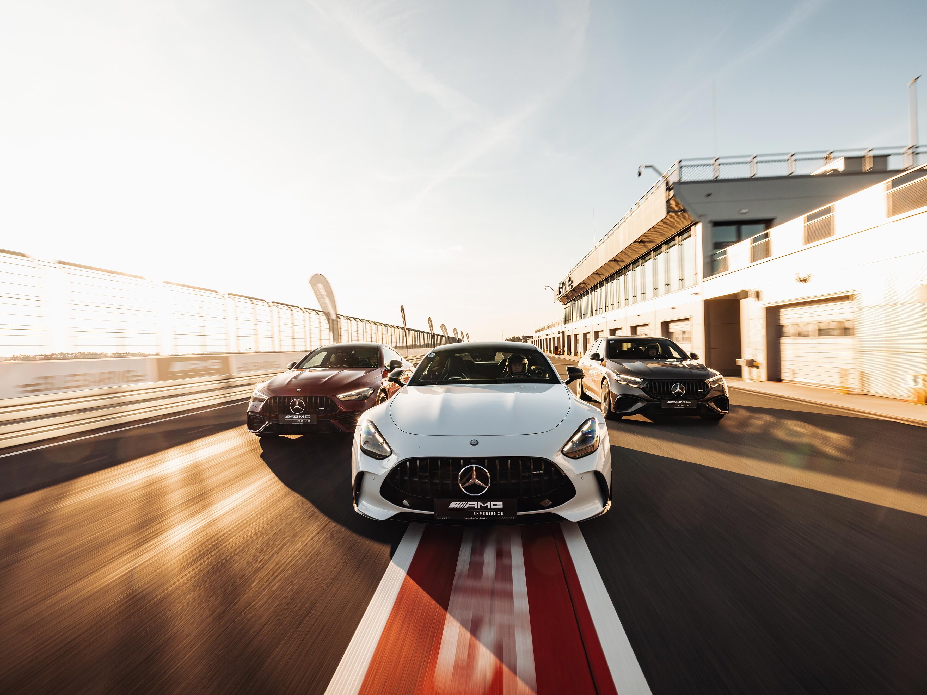 Samochody Mercedes-AMG jadące przez Pit Stop na torze wyścigowym.