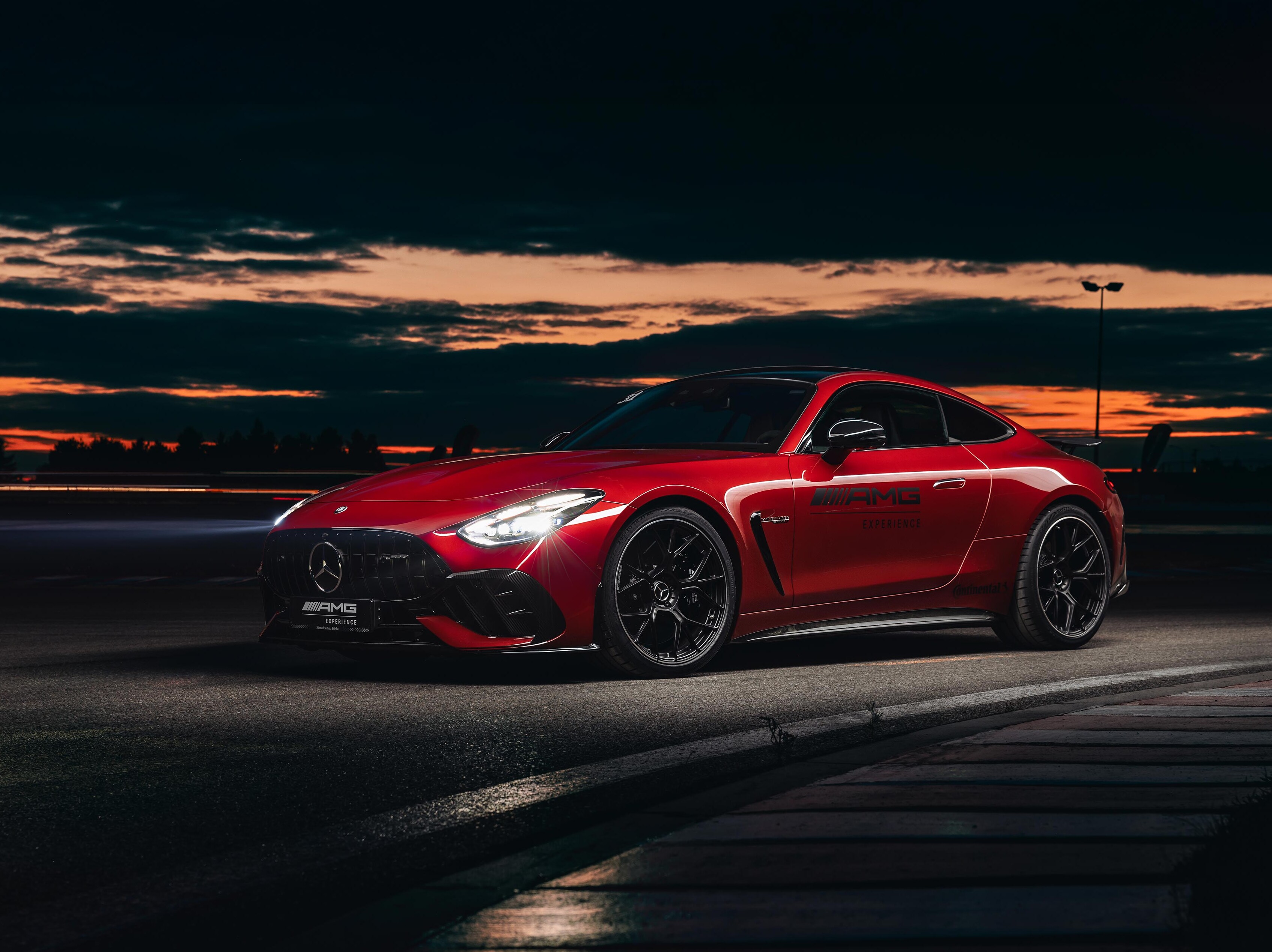 Czerwony Mercedes-AMG GT Coupé z logo AMG Experience na drzwiach.