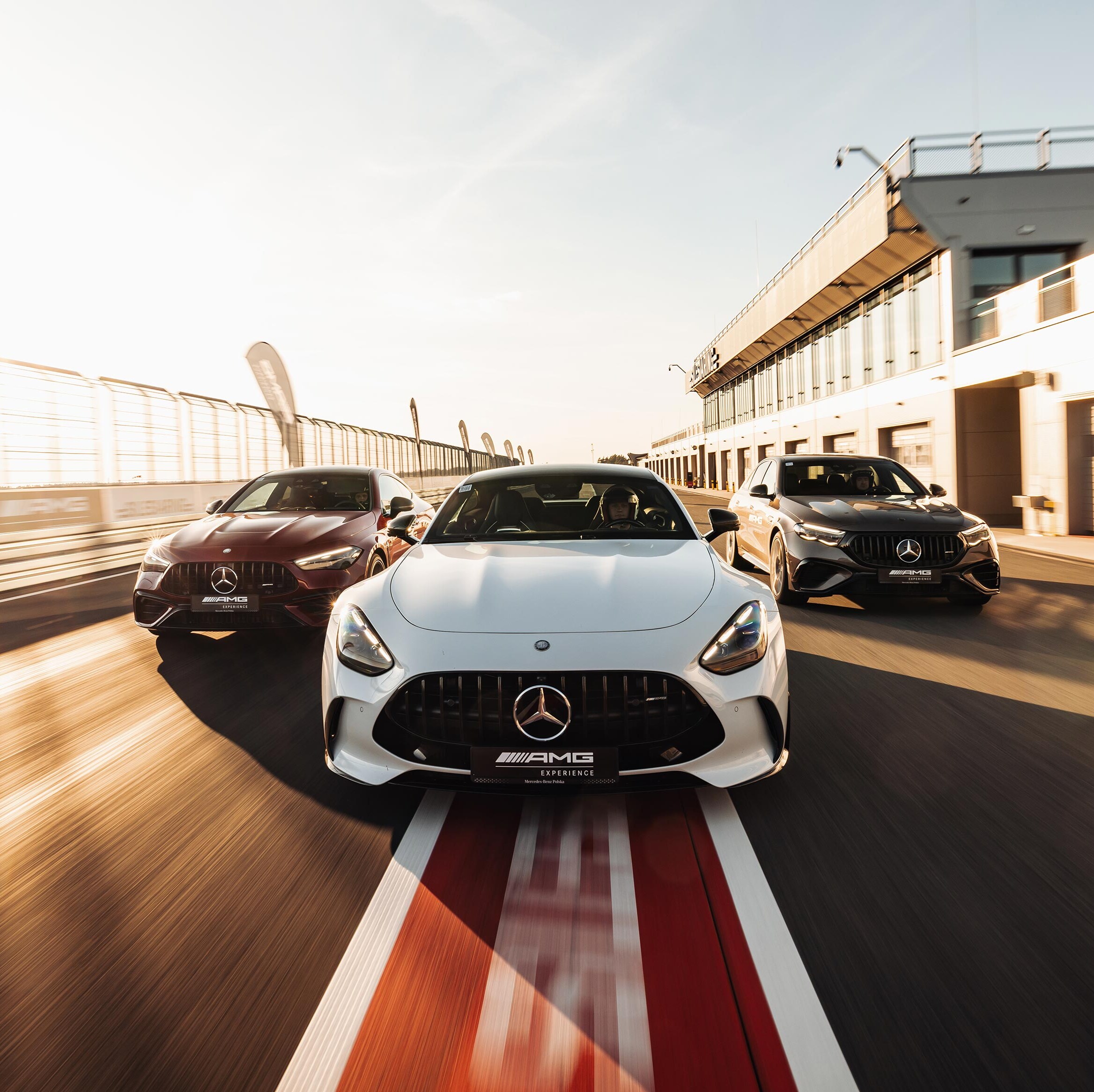 Trzy samochody Mercedes-AMG na torze wyścigowym.