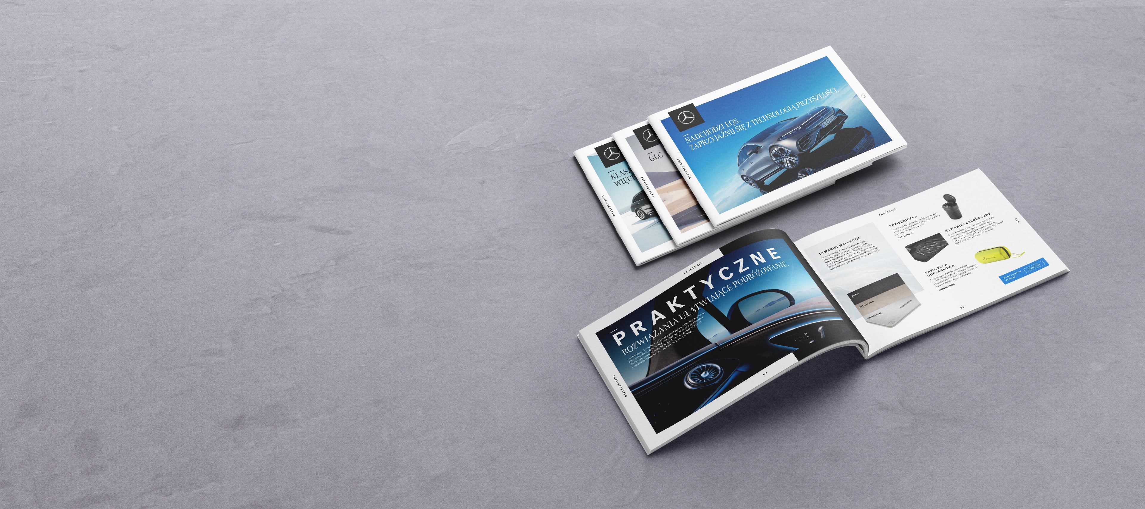 Katalogi akcesoriów do poszczególnych modeli | Mercedes-Benz Katalogi akcesoriów Mercedes-Benz rozłożone na szarej podłodze.