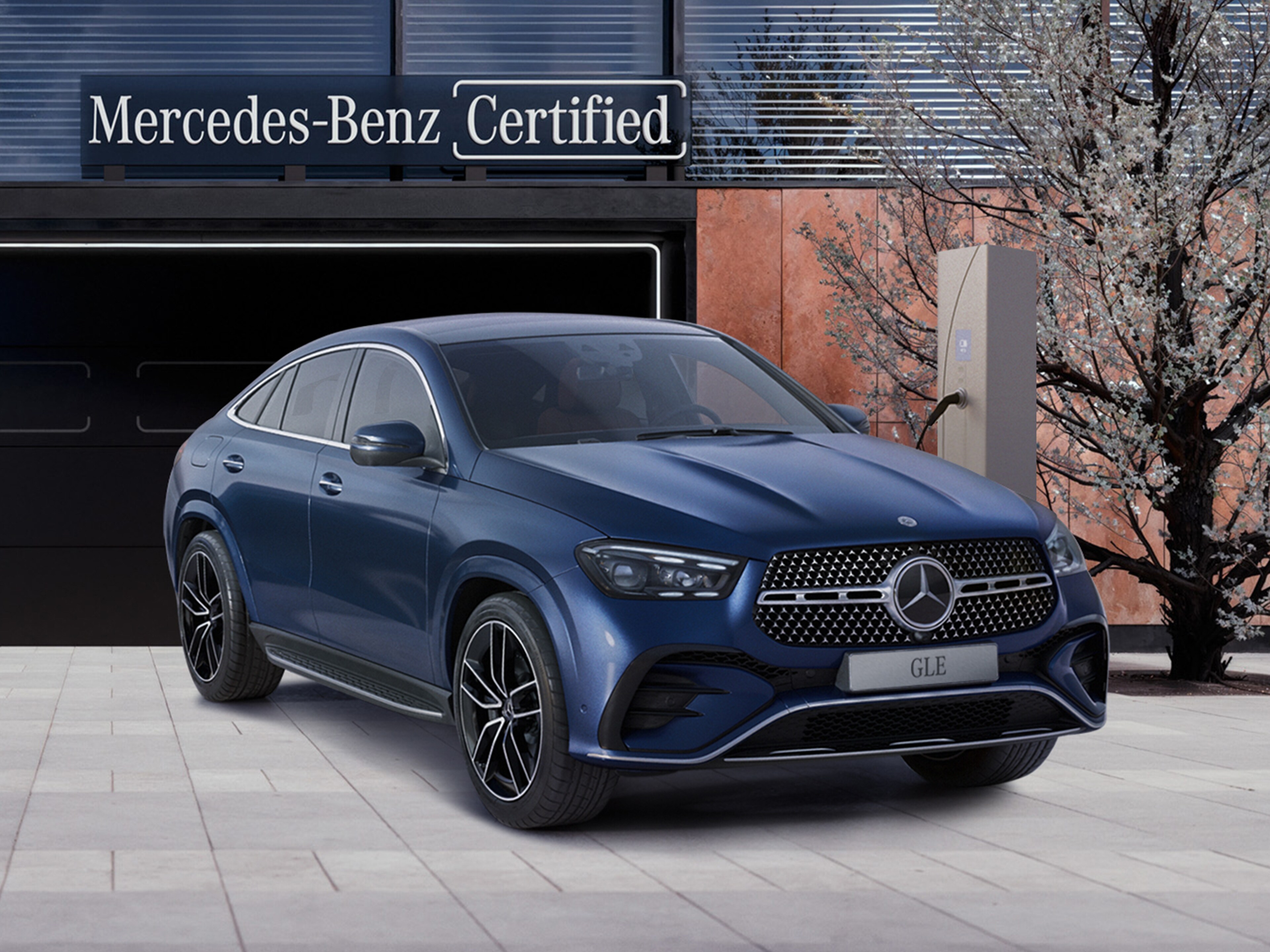 Granatowy model GLE Coupe zaparkowany przed budynkiem.
