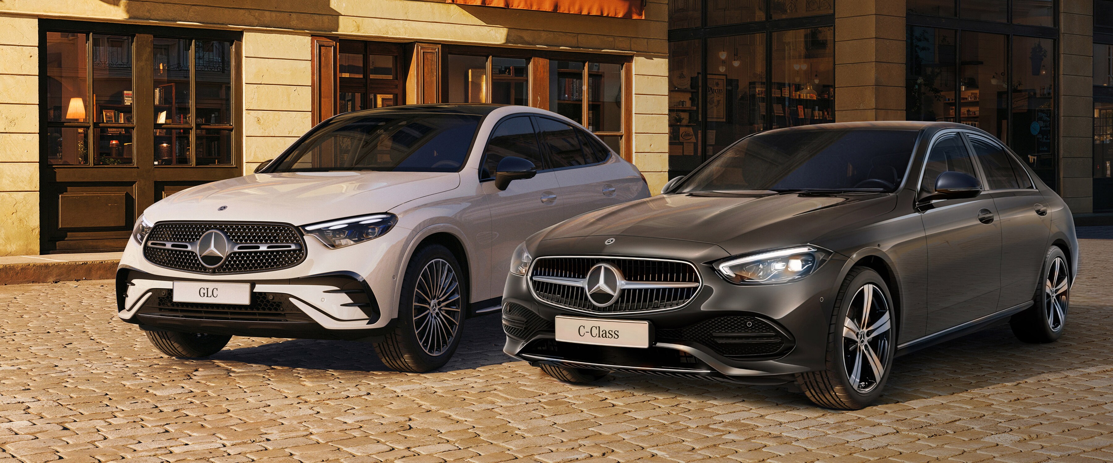 Modele Klasa C oraz GLC Coupe zaparkowane przed budynkiem. 