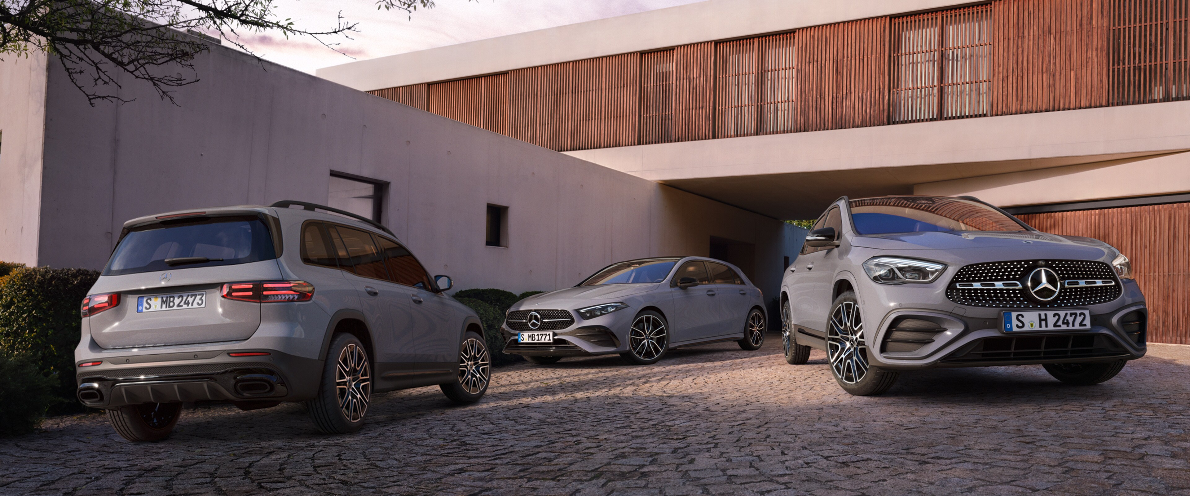 Modele Klasa A, GLA i GLB zaparkowane przed domem. 