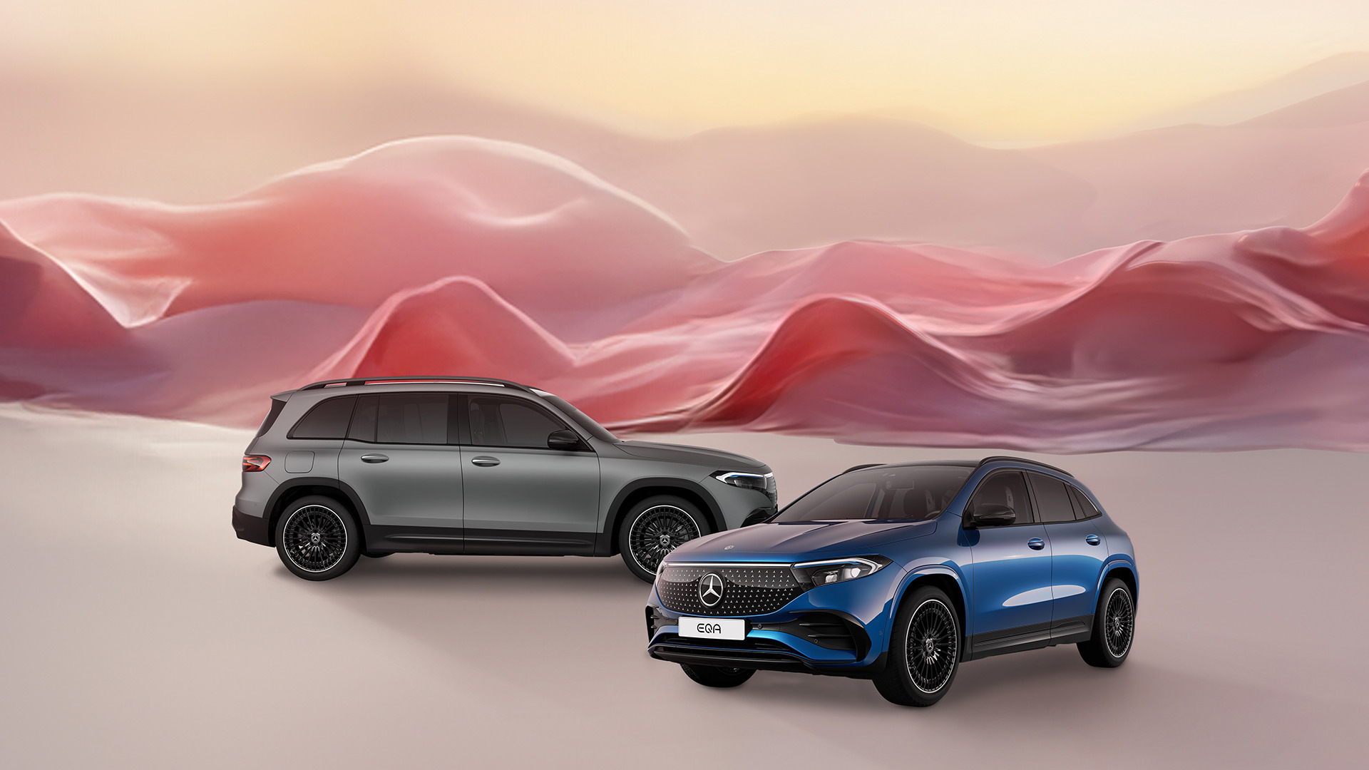 E‑kscytujący świat Mercedes‑Benz Niebieski Mercedes EQA i szary Mercedes EQB na różowym tle.
