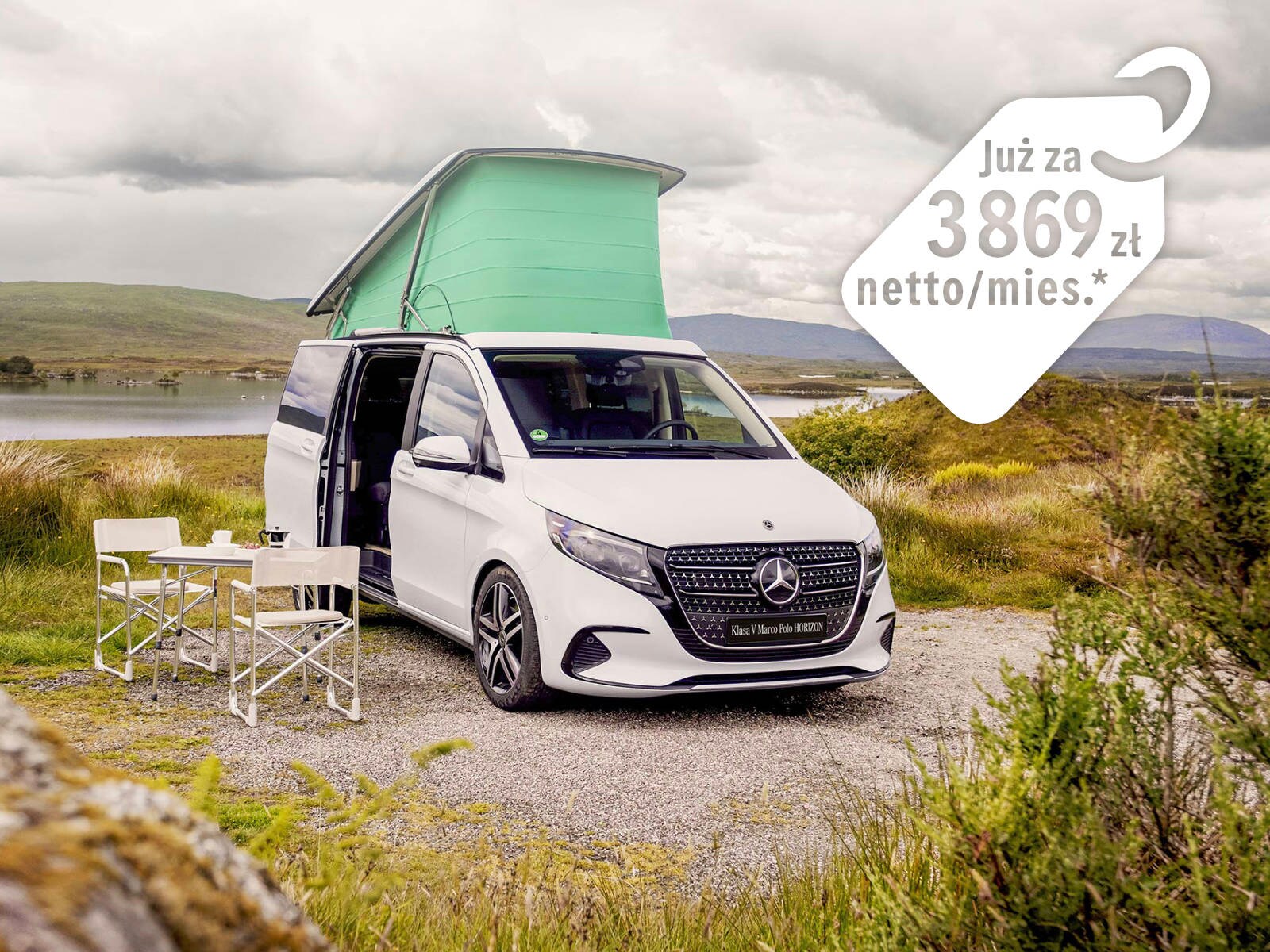 Marco Polo HORIZON z podniesionym dachem i rozstawionym stolikiem na tle pagórkowatego krajobrazu.