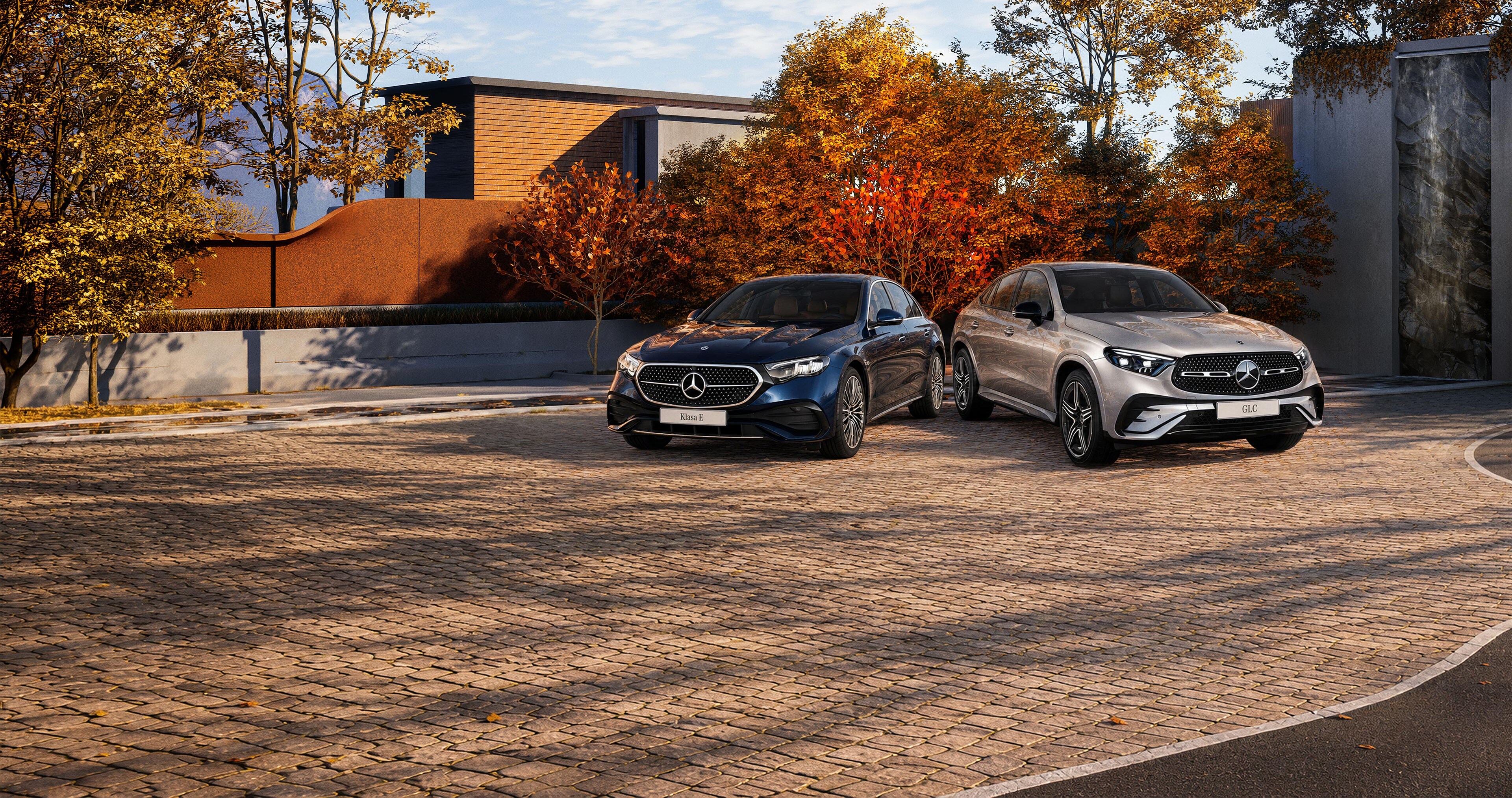 Modele Klasa C Limuzyna oraz GLC Coupe zaparkowane wśród jesiennych drzew.