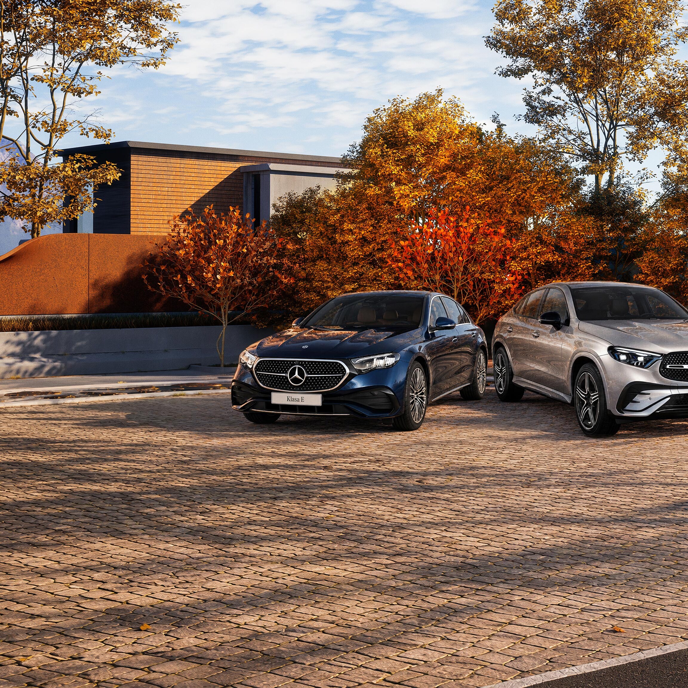 Modele Klasa C Limuzyna oraz GLC Coupe zaparkowane wśród jesiennych drzew.