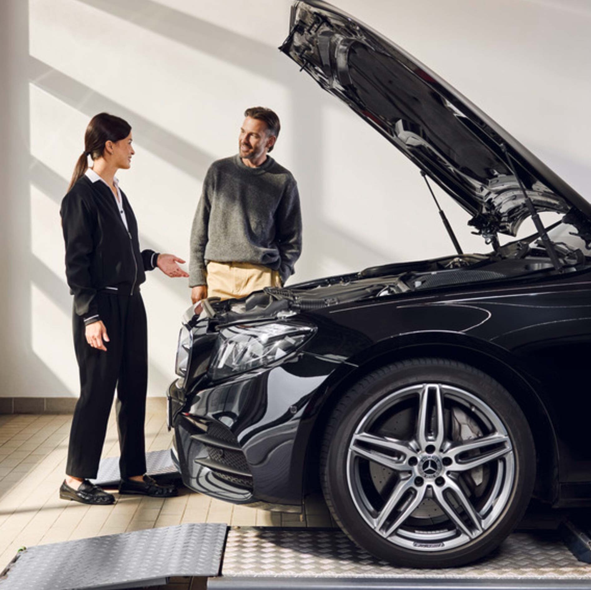 Mężczyzna rozmawiający z pracownicą serwisu Mercedes-Benz.