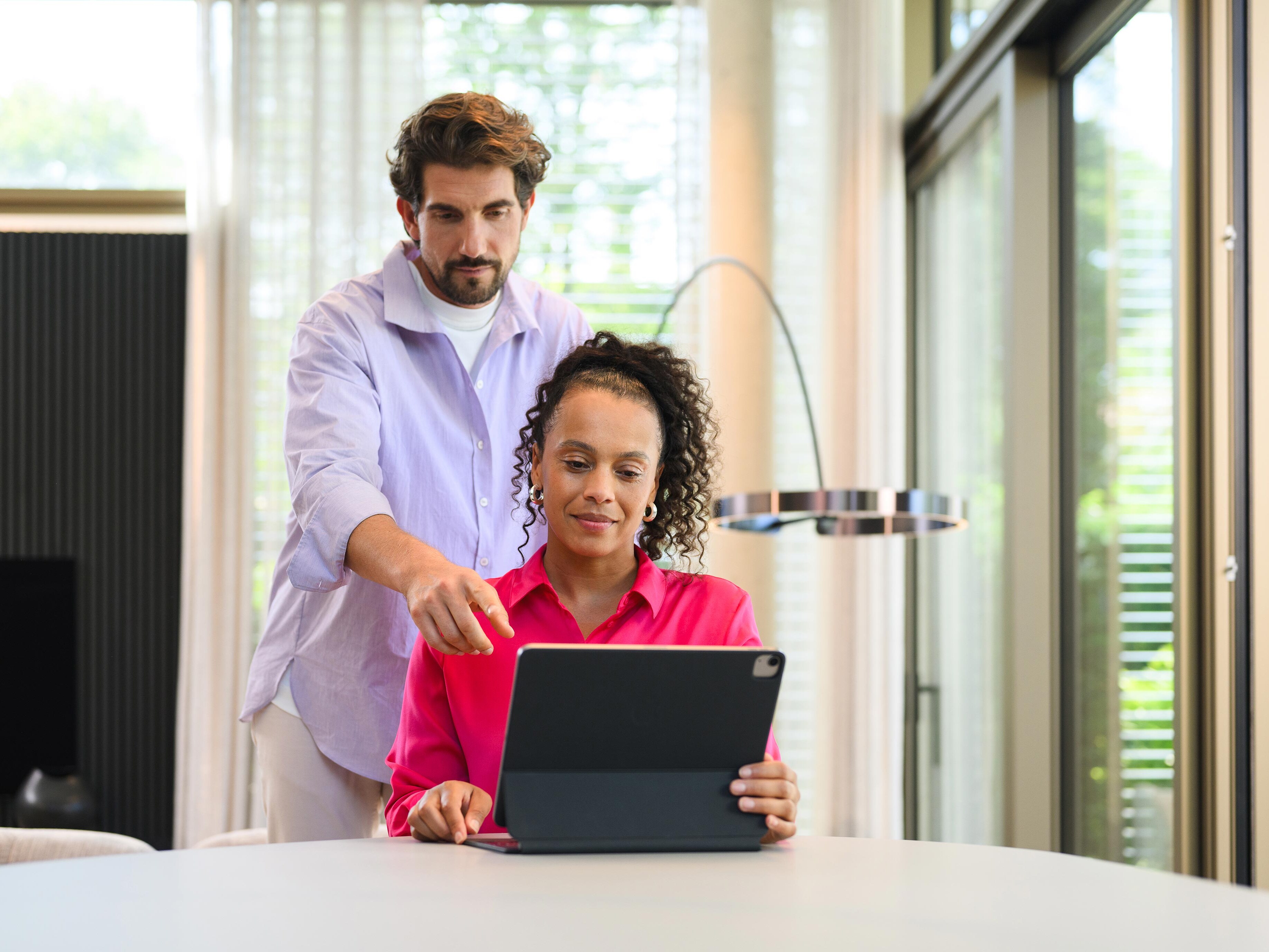 Kobieta i mężczyzna patrzą na ekran laptopa.