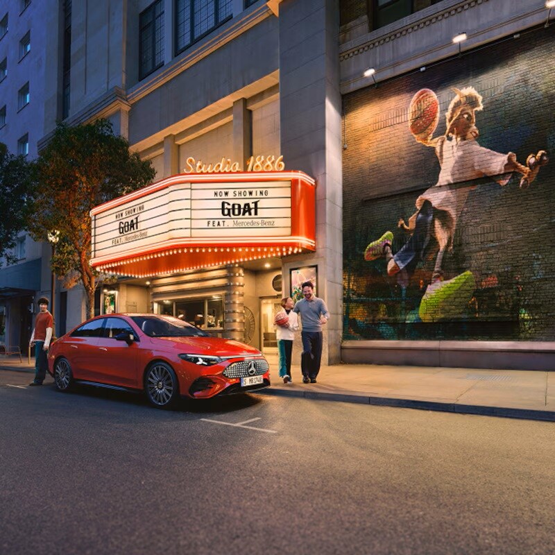Czerwony, elektryczny model CLA zaparkowany przed kinem grającym film GOAT.