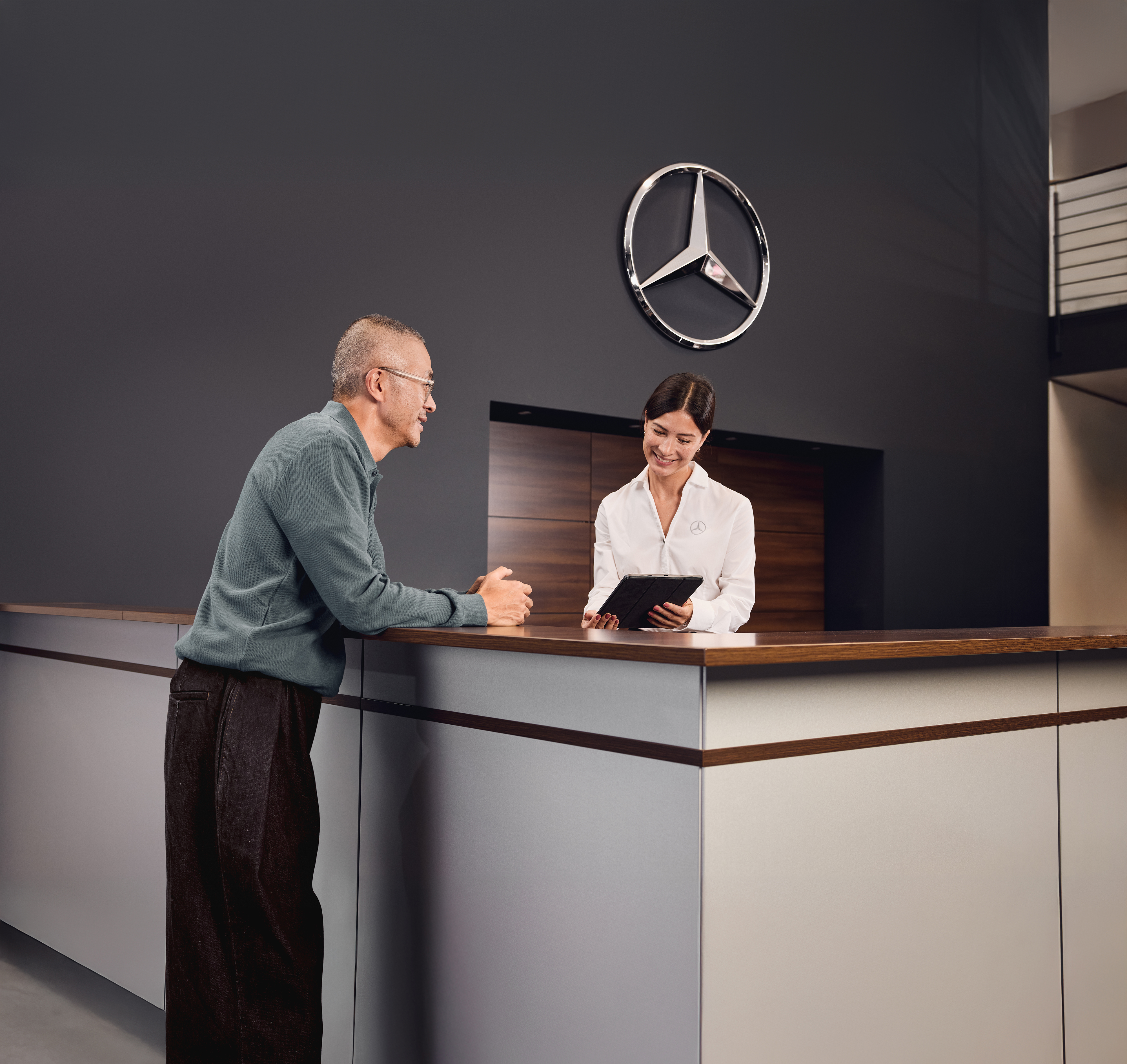 Twój Mercedes wraca do domu! Kobieta i mężczyzna rozmawiają podczas przeglądania informacji na tablecie.