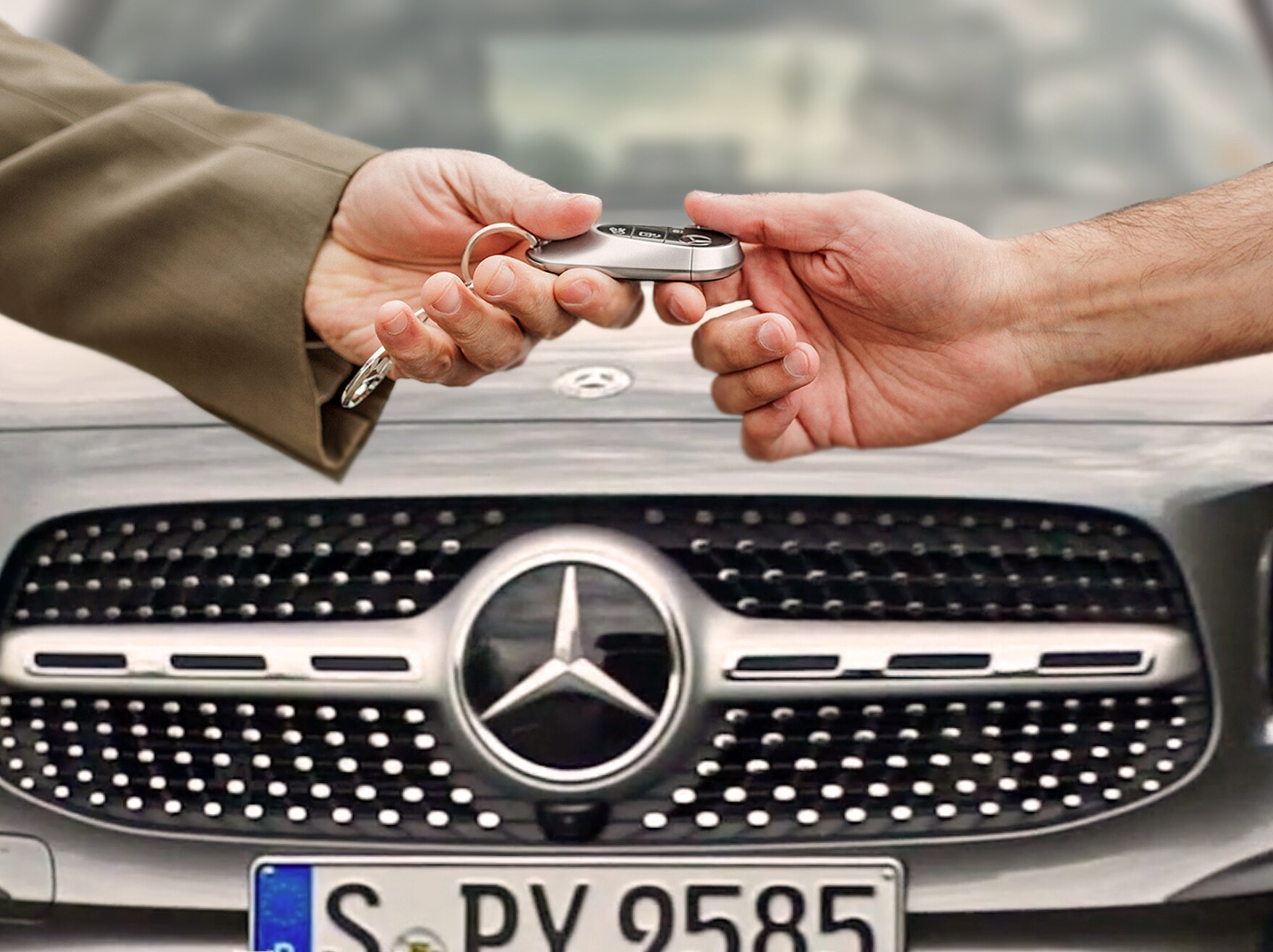 Dwie osoby podające dobie kluczyki do samochodu Mercedes-Benz.