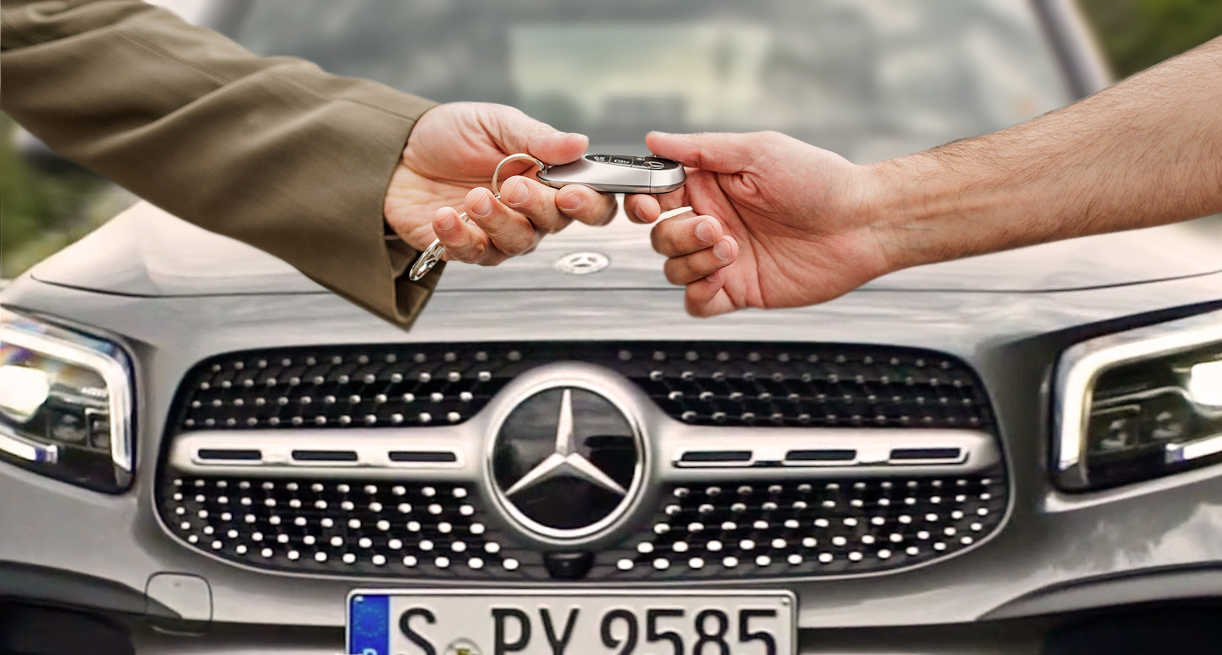 Twój Mercedes wraca do domu! Dwie osoby podające dobie kluczyki do samochodu Mercedes-Benz.