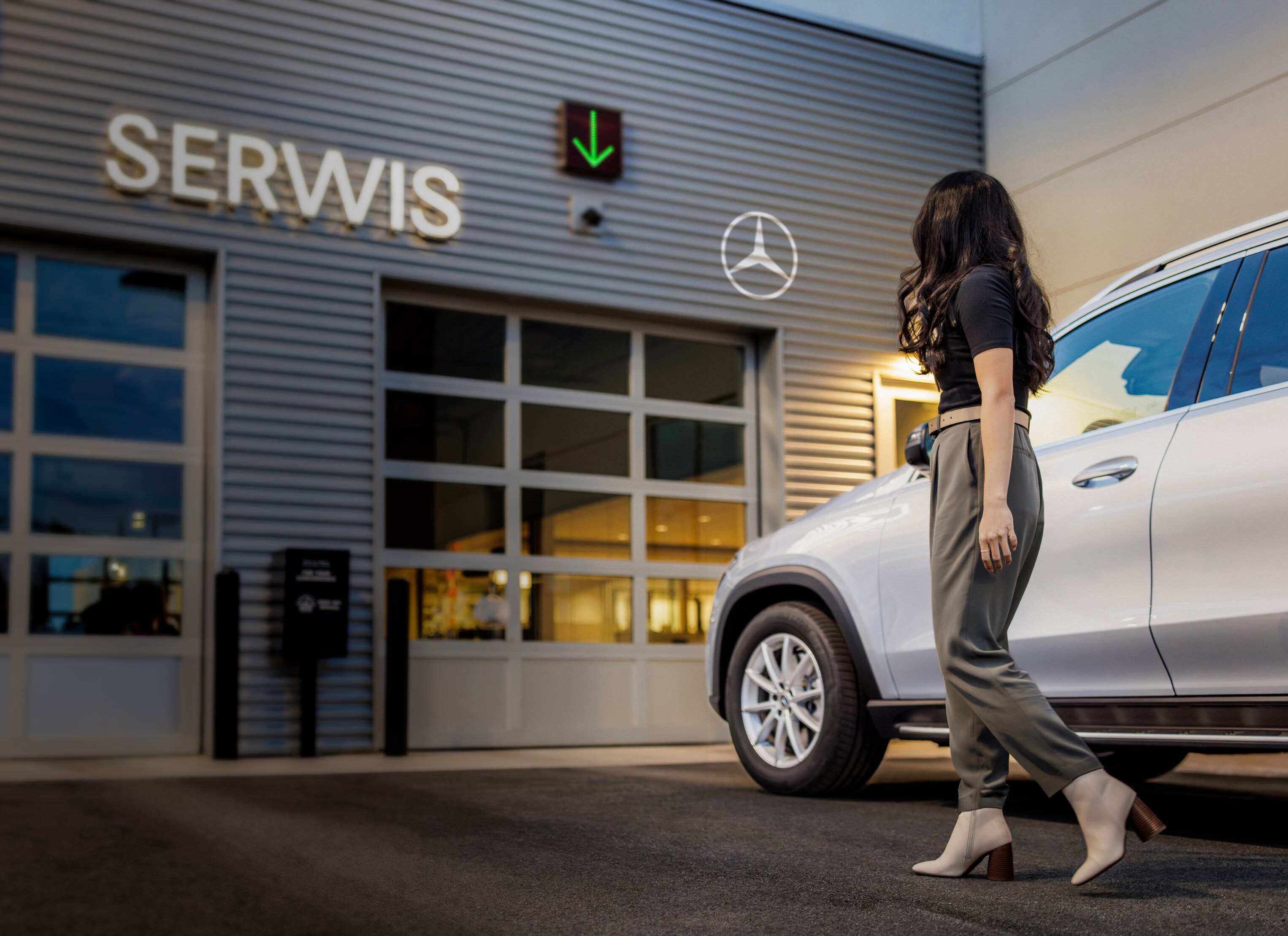 Kobieta idąca w stronę serwisu Mercedes-Benz.