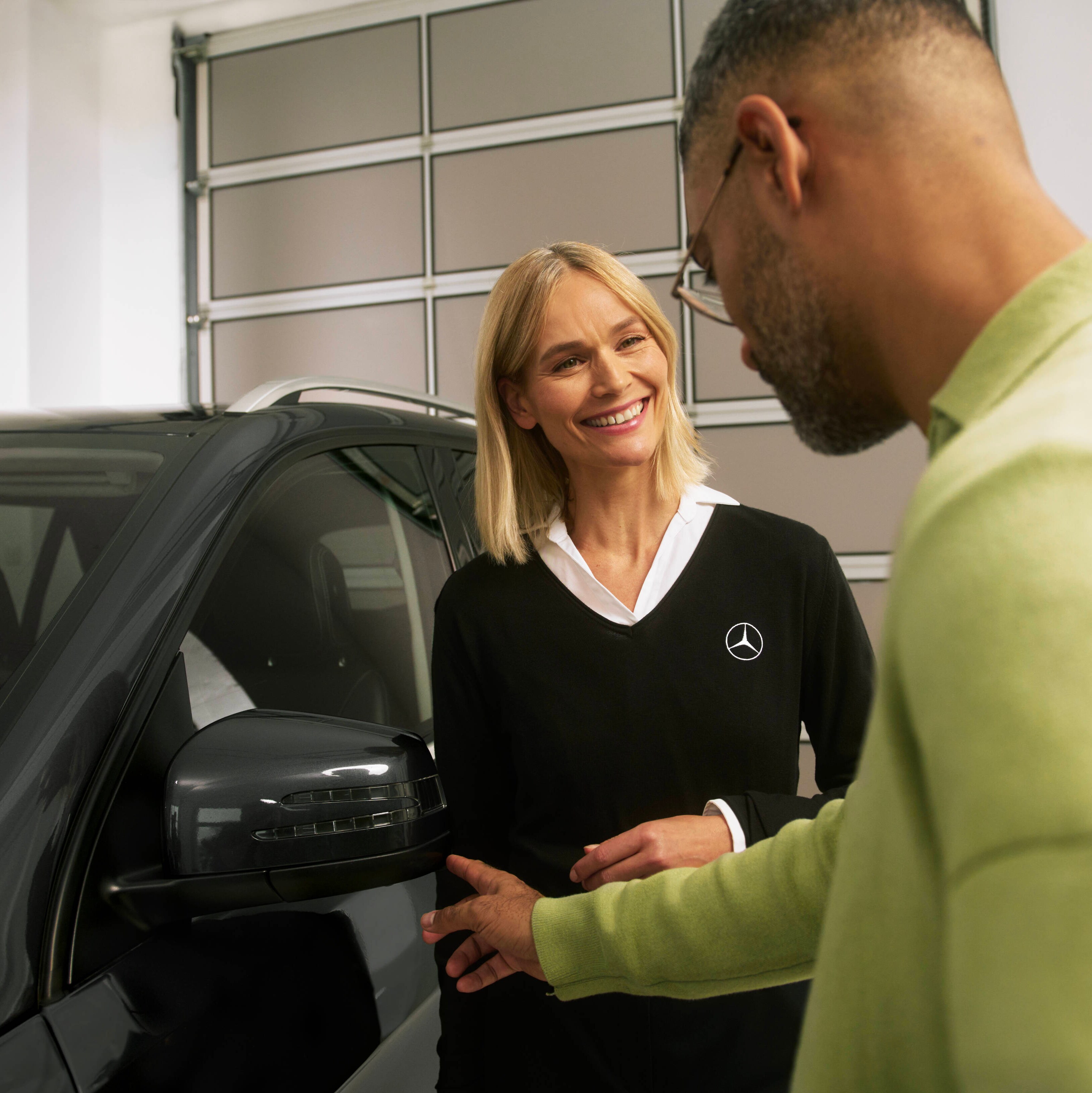 Mężczyzna rozmawiający z pracownicą serwisu Mercedes-Benz.