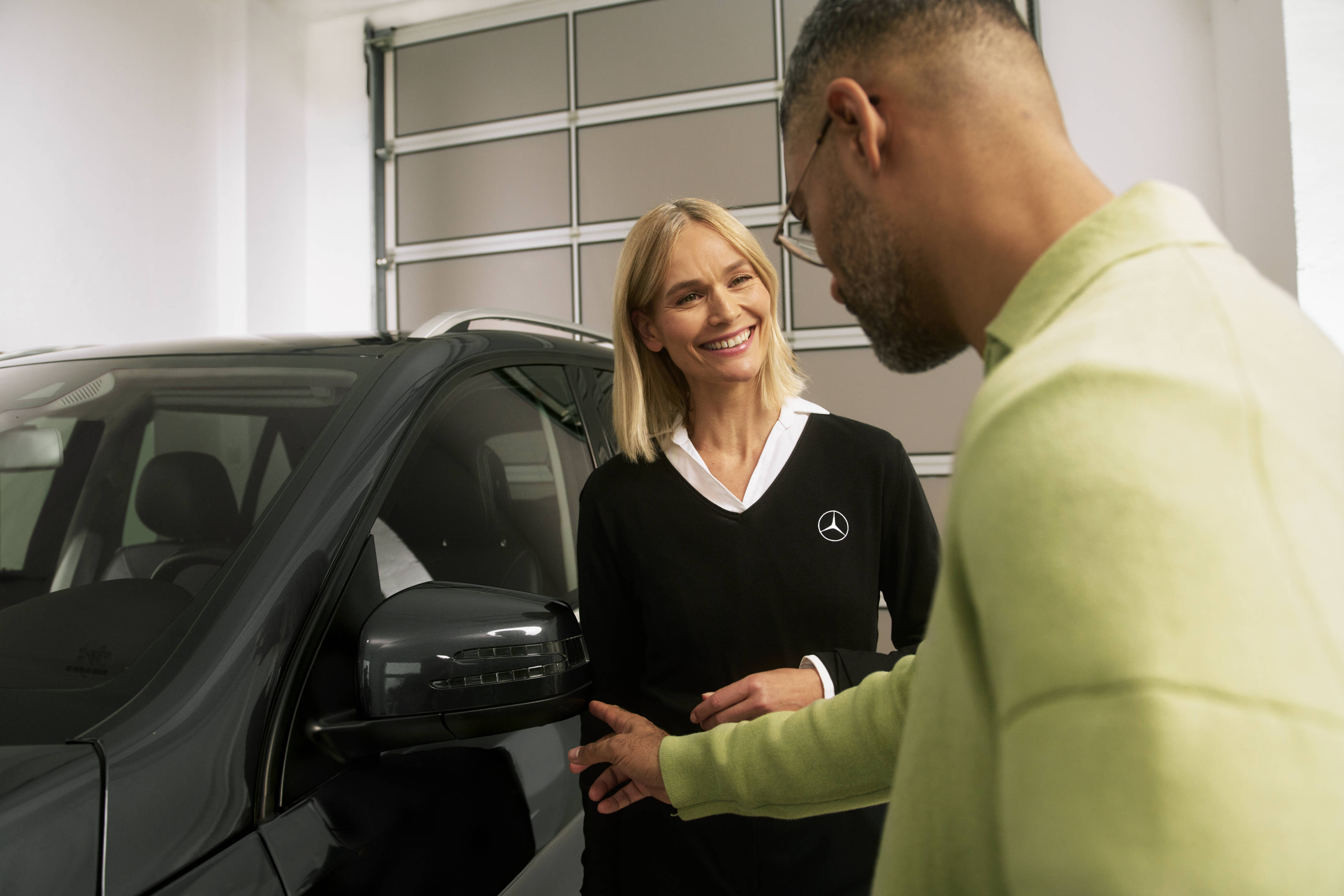 Serwisuj swój starszy model Mercedes-Benz. Mężczyzna rozmawiający z pracownicą serwisu Mercedes-Benz.