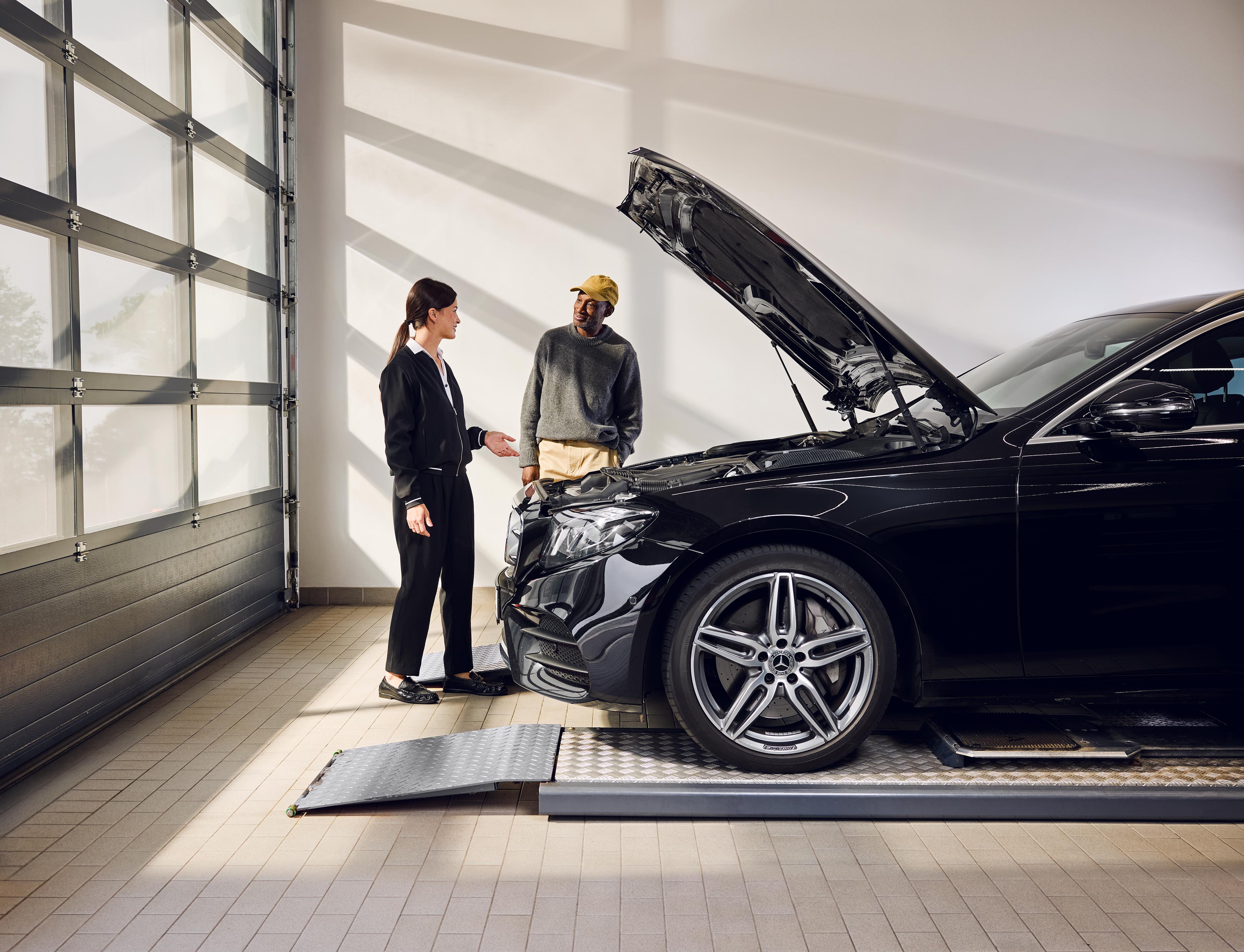 Wymiana oryginalnych części Mercedes-Benz Samochód Mercedes-Benz stoi na rampie serwisowej z otwartą maską podczas wymiany oryginalnych części w centrum serwisowym.