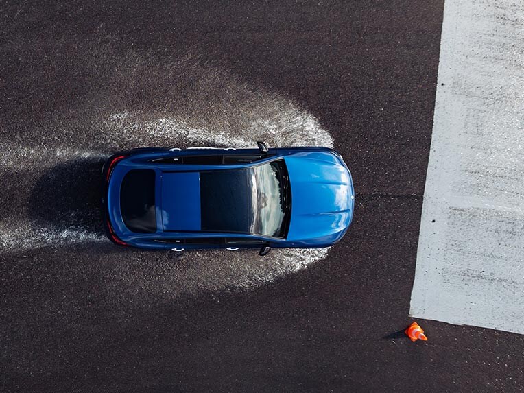 Model Mercedes-Benz jadący po torze wyścigowym w deszczu. 