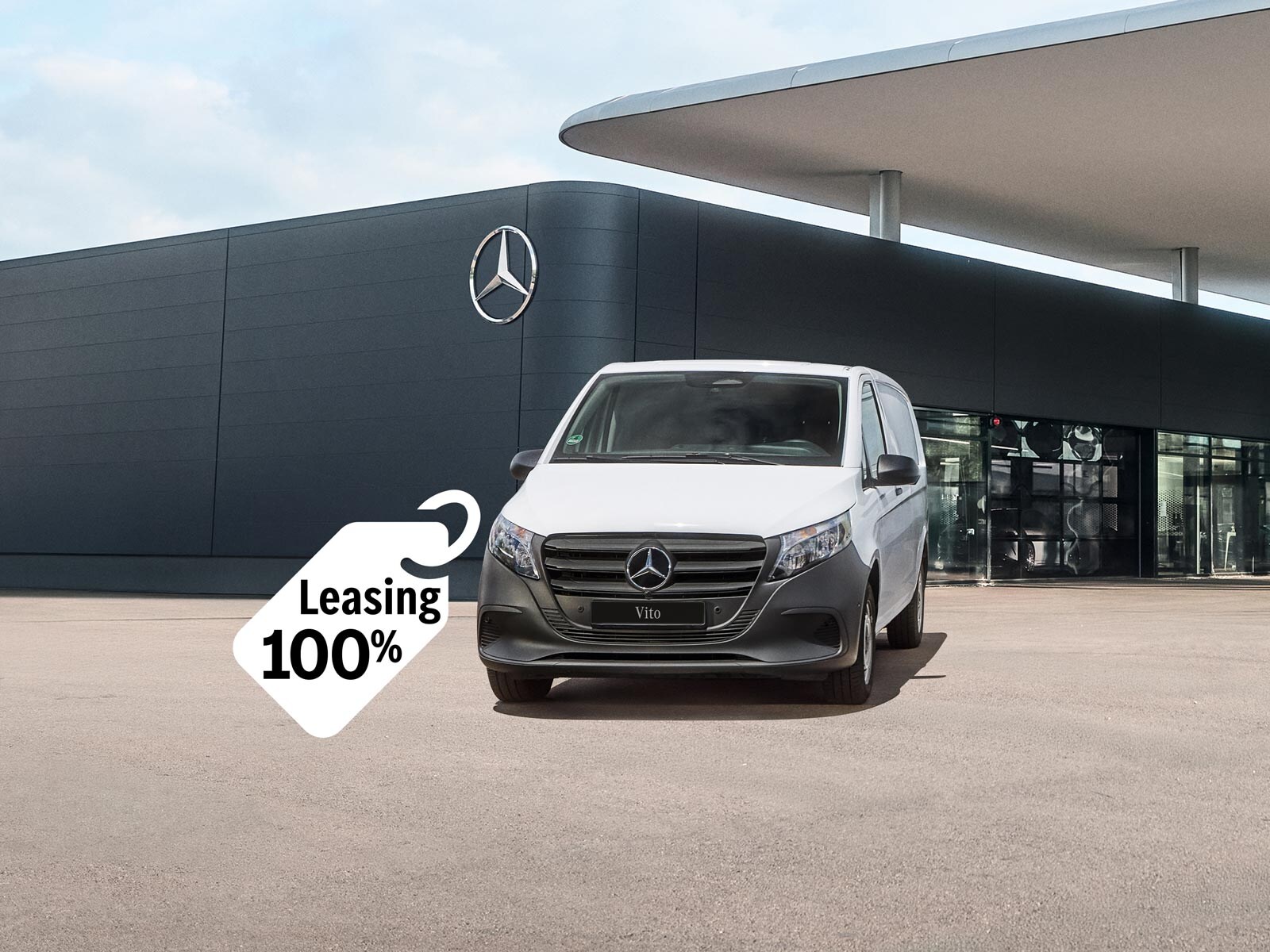 Biały Vito Mercedes-Benz zaparkowany przed salonem Mercedes-Benz. Obok unosi się plakietka z napisem „Leasing 100%”.