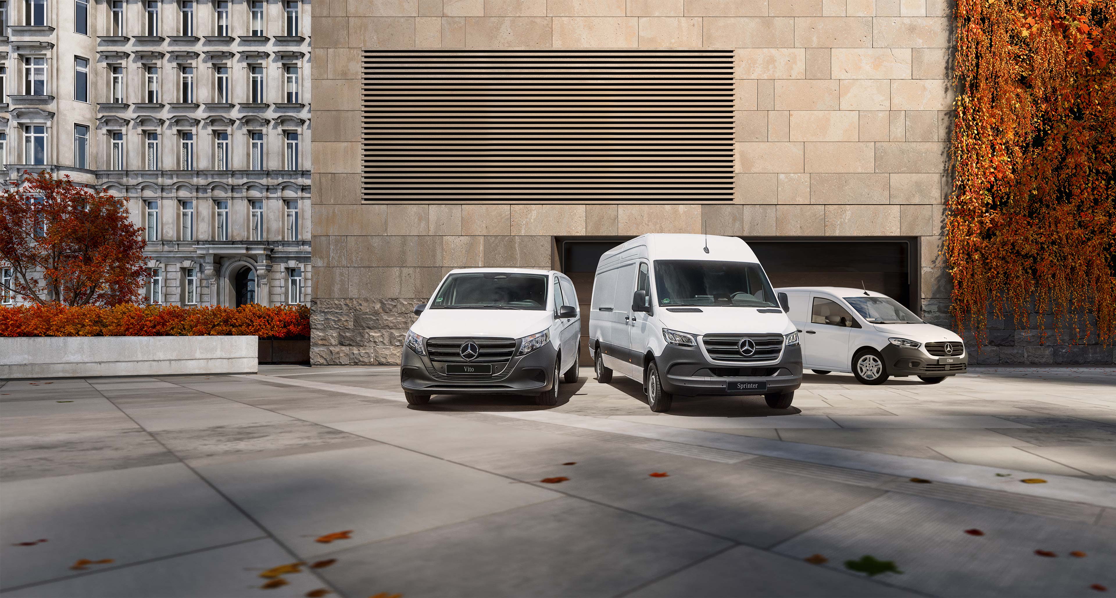 Jesień dobrych decyzji w Mercedes-Benz! | Samochody dostawcze Mercedes-Benz Modele Citan, Vito i Sprinter stoją zaparkowane przed nowoczesnym budynkiem w jesiennej scenerii.